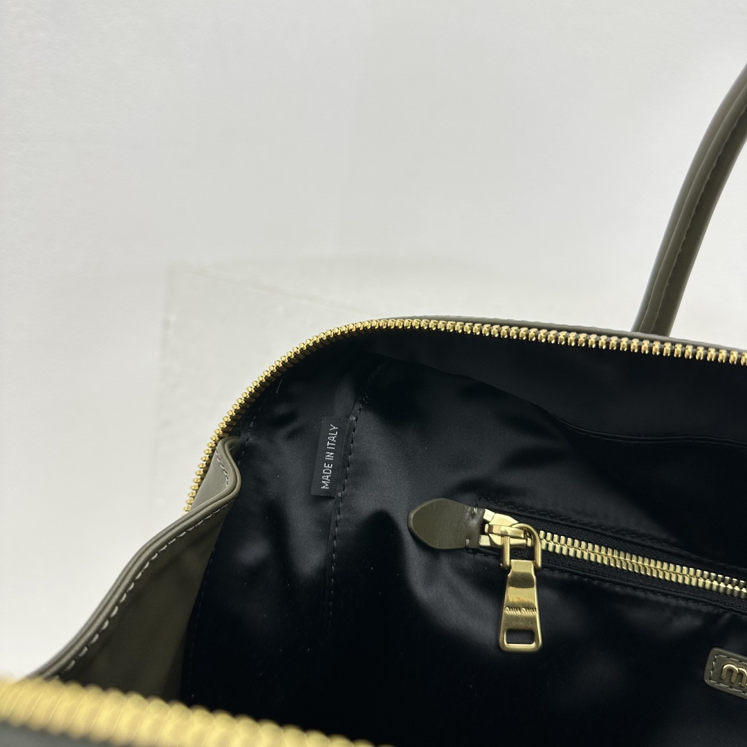 墨绿MiuMi新款公文包代当之无愧的top热门选手经典大气的保龄球包造型设计给整体增添一丝帅气与Miu少