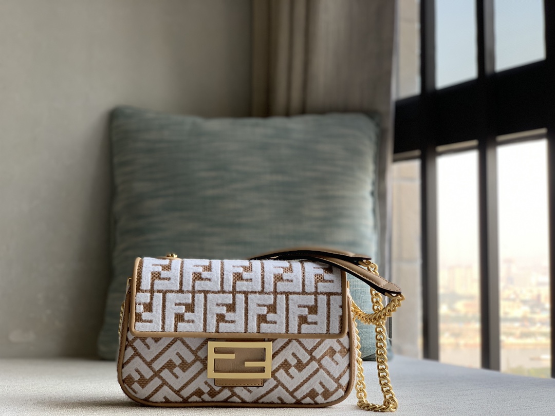 Fendi's signature medium Baguette with chain tote, woven in original raffia and embroidered with a brocade-effect chenille FF pattern for a uniqu