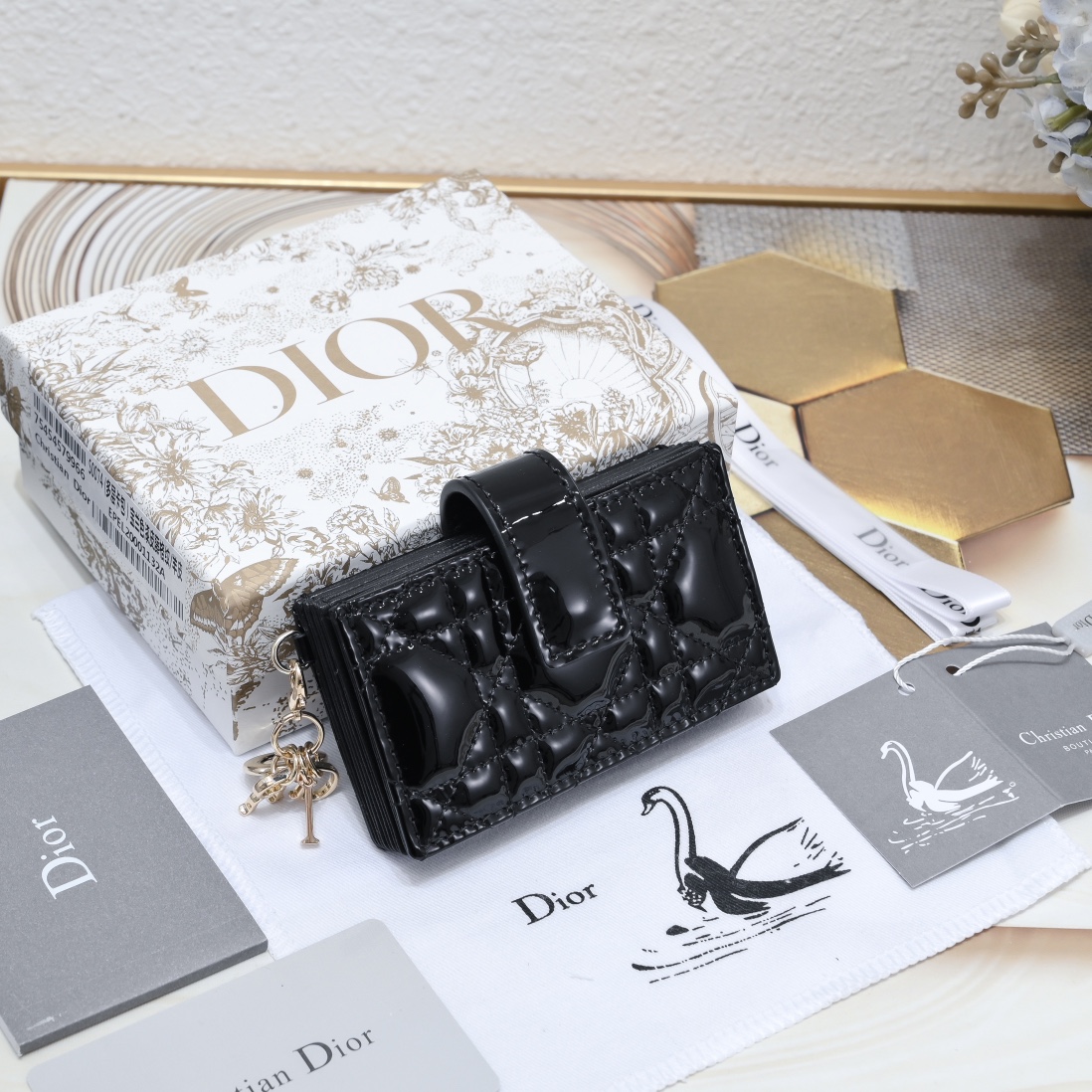 Dior 这款 Lady 5 格卡夹饰有 的藤格纹缉面线 采用外面亮漆皮+内裡羊皮精心制作