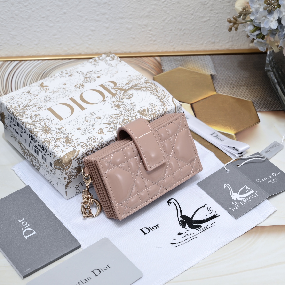 Dior 这款 Lady 5 格卡夹饰有 的藤格纹缉面线 采用外面亮漆皮+内裡羊皮精心制作