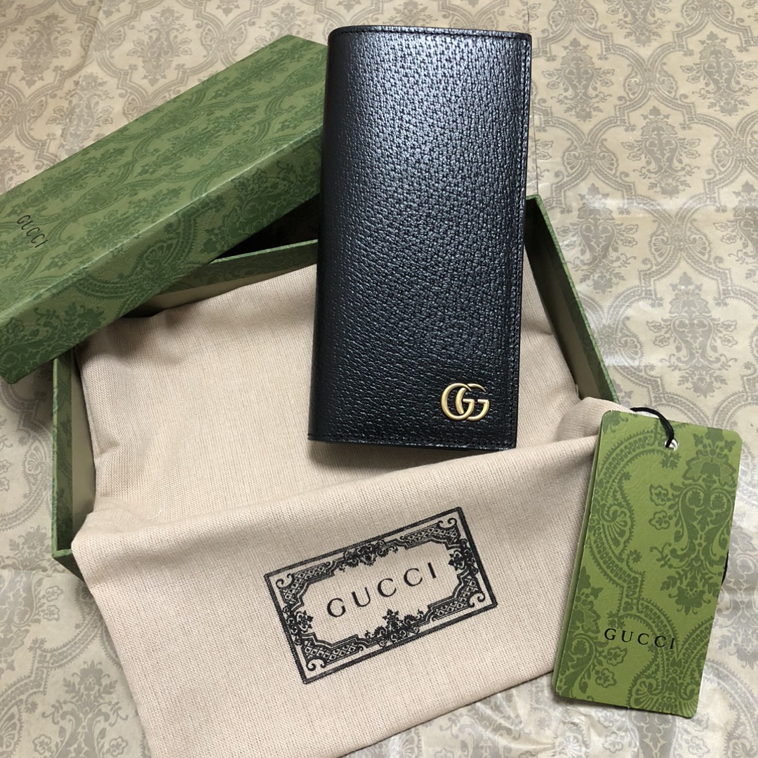 此系列配以醒目的标志性双 G 金属配件。采用热压小牛皮制作，以获得野猪猪皮效果，营造织纹外观。款号：。尺
