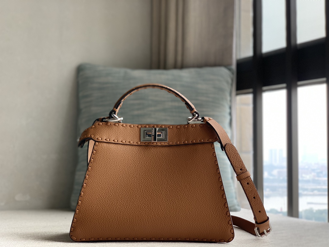Fendi's iconic Peekaboo ISeeU small handbag, made of brown Cuoio Romano leather, decorated with hand-stitching of the same color, and classic twi