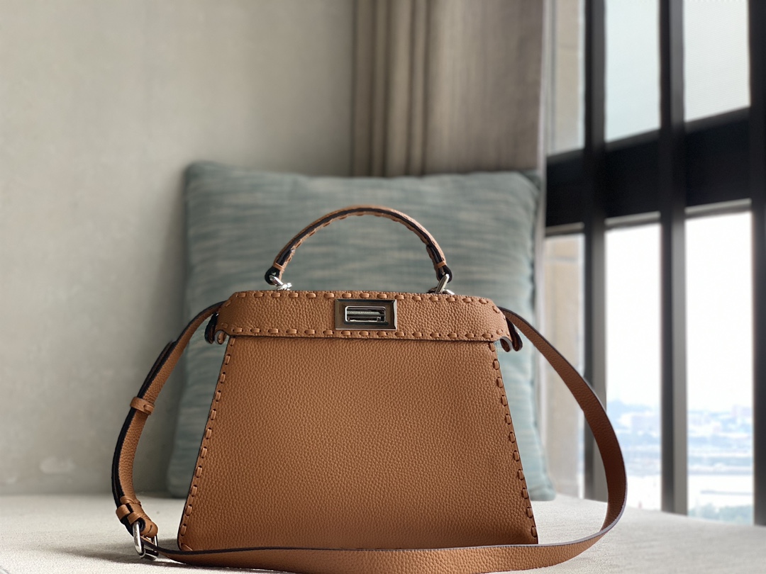 Fendi's iconic Peekaboo ISeeU small handbag, made of brown Cuoio Romano leather, decorated with hand-stitching of the same color, and classic twi