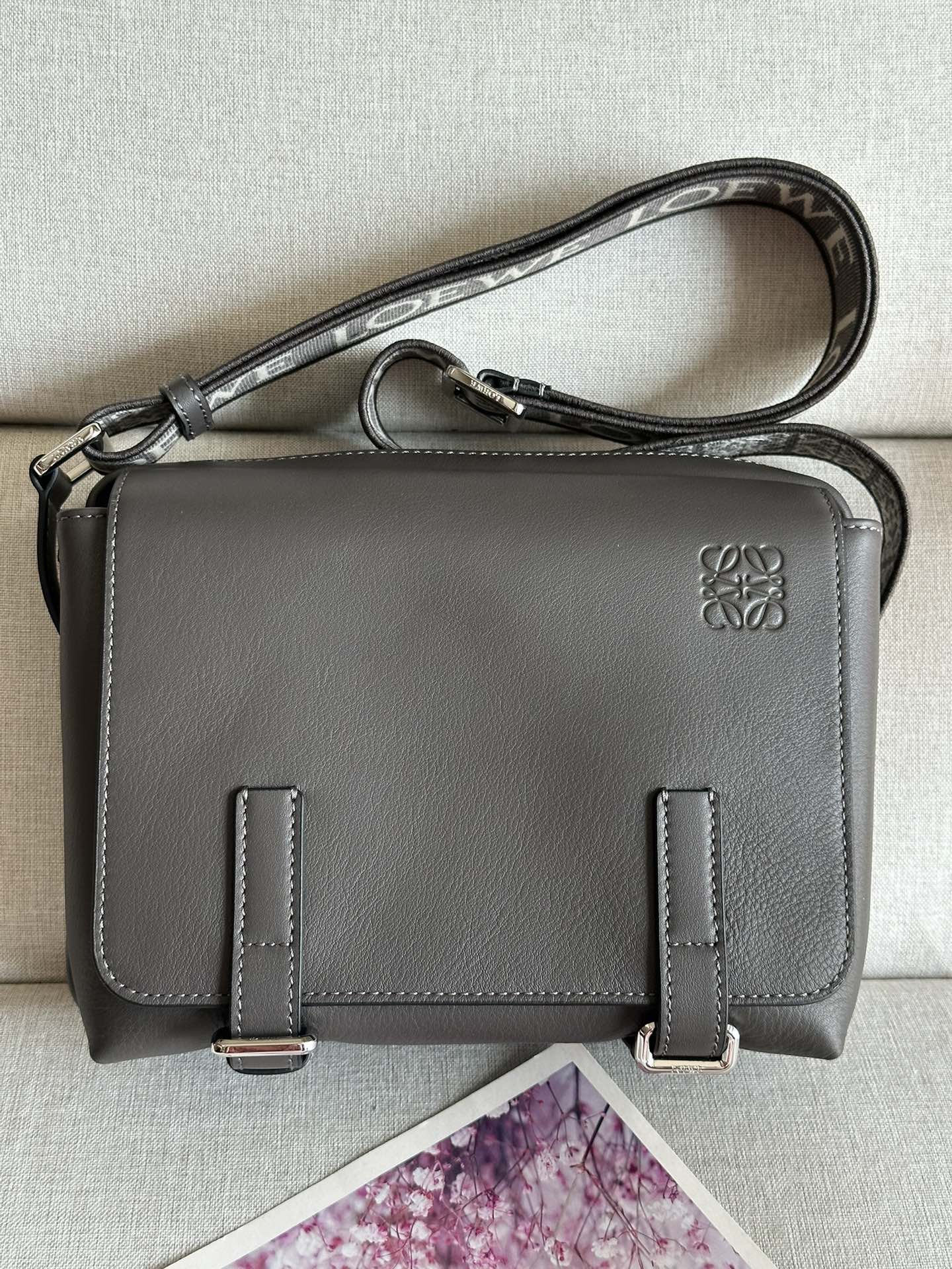 NO:175685,Loewe's new XS postman bag A74 gray-coffee: Size 23-18-9cm military messenger classic messenger bag. This model changes the past classic postman bag method and designs a zipper main compartment. The front is matched with a buckle to open and private items, which is more user-friendly. The overall feeling is more flawless. Built-in two card slots, cigarettes, mobile phones, power banks, wallets, storage ideal index 5 stars. Imported lychee pattern calfskin and soft fine-line leather calfskin on the back, and adjusted cotton webbing shoulder straps, which doubles the comfort! , special Loewe, loewe, loewe, cowhide19860909Loewe 新款XS邮差包 A74灰咖色 :尺寸23-18-9cm military messenger经典信使包 ,此款一改过去经典邮差包做法,设计了拉链主隔层,前部搭配搭扣打开方式放隐私物品,安全之余更加人性化.整體感覺更無懈可击.内置两卡槽,香烟,手机,充电宝,钱夹,收纳理想指数5颗星 采用进口荔枝纹小牛皮搭配背部柔软细纹皮小牛皮,调节的棉质织带肩带,使用舒适感倍增！,特级罗意威,loewe,loewe,cowhide,Bag