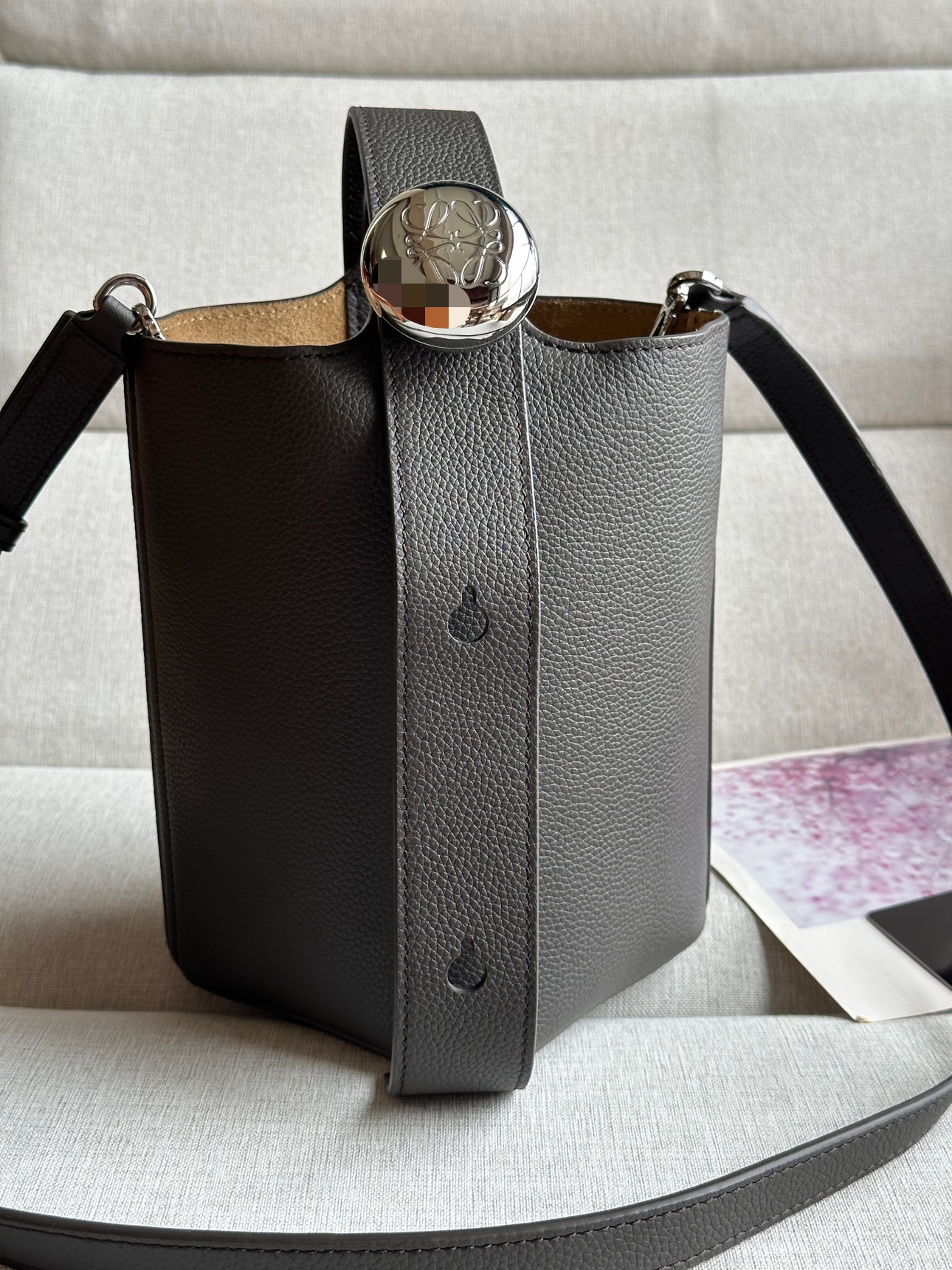 NO:179420,Mini Soft Grain Cowhide Leather Pebble Bucket Handbag Pebble cleverly combines pure simple lines with eye-catching design style to create a unique and innovative handbag design. The iconic Anagram engraving hardware combines decorative and practical functions, adjusts the length of the shoulder strap and is suitable for a variety of carrying methods. The unique twisted structure complements the delicate details. This mini version is made of soft grain cowhide. It can be cross-body, shoulder or hand-held * Adjustable removable shoulder strap * Magnetic buckle closure * Inner bag * Synthetic leather lining * Anagram engraving pebble model number 332s Color chocolate color Size 20CM ~ 16CM ~ 13, Superior Loewe, cowhide19860909迷你柔软粒面牛皮革 Pebble Bucket 水桶手袋Pebble将纯粹的简约线条与瞩目设计风格巧妙融合造就别具一格的创新的手袋设计.标志性的 Anagram 雕刻五金件兼具装饰和实用功能,可调节肩带长度并适合多种携带方式,独特的扭曲结构与微妙的细节相得益彰.此迷你版本采用柔软粒面牛皮革制成.可斜挎、肩背或手提＊可调节可拆卸肩带＊磁扣开合＊内袋＊合成革衬里* Anagram 雕刻卵石 款号332s 颜色巧克力色 尺寸高20CM～袋口16CM～13,特级罗意威,loewe,cowhide,Bag