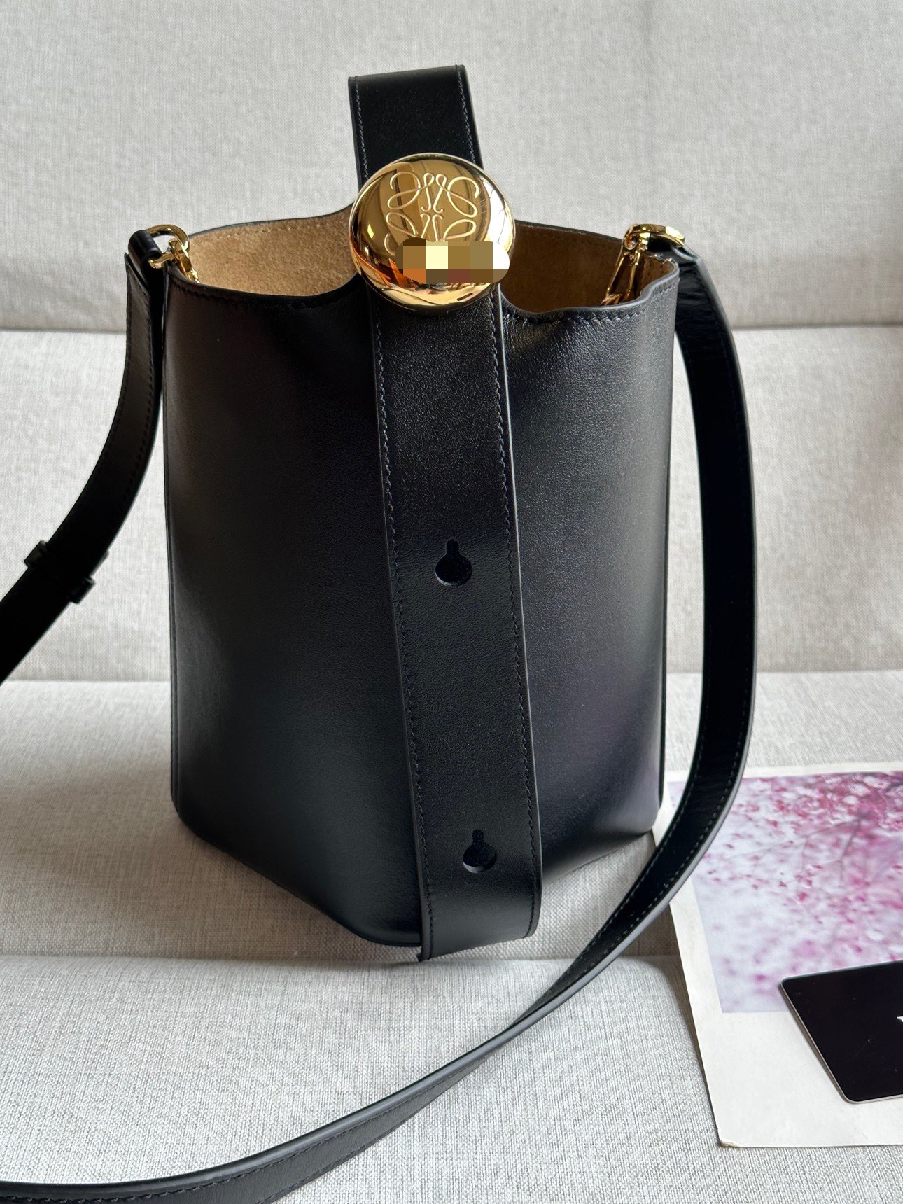 NO:179418,Mini Soft Grain Cowhide Leather Pebble Bucket Handbag Pebble cleverly combines pure simple lines with eye-catching design style to create a unique and innovative handbag design. The iconic Anagram engraving hardware combines decorative and practical functions, adjusts the length of the shoulder strap and is suitable for a variety of carrying methods. The unique twisted structure complements the delicate details. This mini version is made of soft grain cowhide. It can be cross-body, shoulder or hand-held * Adjustable removable shoulder strap * Magnetic buckle closure * Inner bag * Synthetic leather lining * Anagram engraving pebble model number 332s Color black Size 20CM ~ 16CM ~ 13, Superior Loewe, cowhide19860909迷你柔软粒面牛皮革 Pebble Bucket 水桶手袋Pebble将纯粹的简约线条与瞩目设计风格巧妙融合造就别具一格的创新的手袋设计.标志性的 Anagram 雕刻五金件兼具装饰和实用功能,可调节肩带长度并适合多种携带方式,独特的扭曲结构与微妙的细节相得益彰.此迷你版本采用柔软粒面牛皮革制成.可斜挎、肩背或手提＊可调节可拆卸肩带＊磁扣开合＊内袋＊合成革衬里* Anagram 雕刻卵石 款号332s 颜色黑色 尺寸高20CM～袋口16CM～13,特级罗意威,loewe,cowhide,Bag