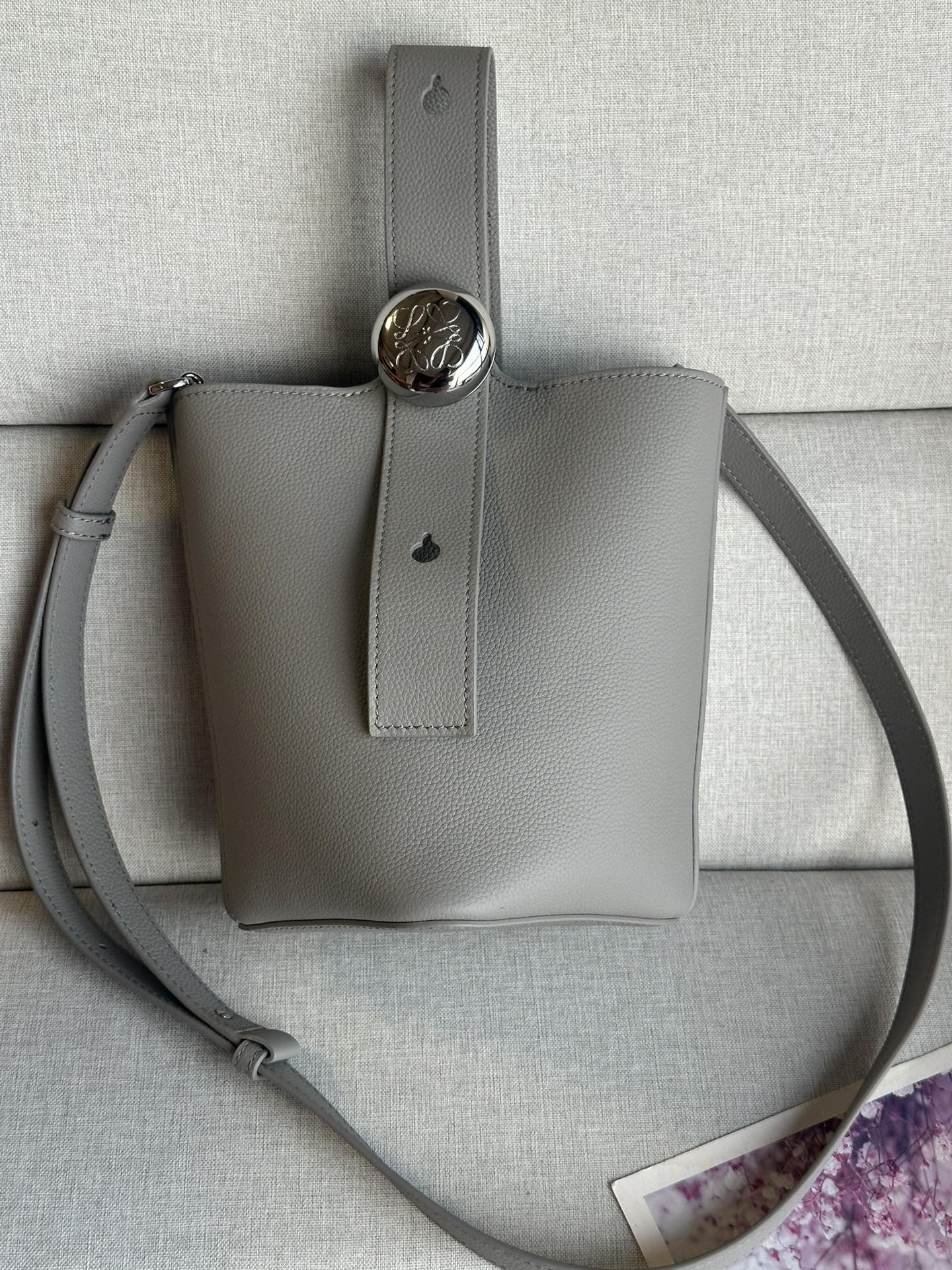 NO:179448,Mini Soft Grain Cowhide Leather Pebble Bucket Handbag Pebble cleverly combines pure simple lines with eye-catching design style to create a unique and innovative handbag design. The iconic Anagram engraving hardware combines decorative and practical functions, adjusts the length of the shoulder strap and is suitable for a variety of carrying methods. The unique twisted structure complements the delicate details. This mini version is made of soft grain cowhide. It can be cross-body, shoulder or hand-held * Adjustable removable shoulder strap * Magnetic buckle closure * Inner bag * Synthetic leather lining * Anagram engraving pebble model number 332s Dimensions 20CM ~ 16CM ~ 13, special grade Loewe, cowhide19860909迷你柔软粒面牛皮革 Pebble Bucket 水桶手袋Pebble将纯粹的简约线条与瞩目设计风格巧妙融合造就别具一格的创新的手袋设计.标志性的 Anagram 雕刻五金件兼具装饰和实用功能,可调节肩带长度并适合多种携带方式,独特的扭曲结构与微妙的细节相得益彰.此迷你版本采用柔软粒面牛皮革制成.可斜挎、肩背或手提＊可调节可拆卸肩带＊磁扣开合＊内袋＊合成革衬里* Anagram 雕刻卵石 款号332s 尺寸高20CM～袋口16CM～13,特级罗意威,loewe,cowhide,Bag