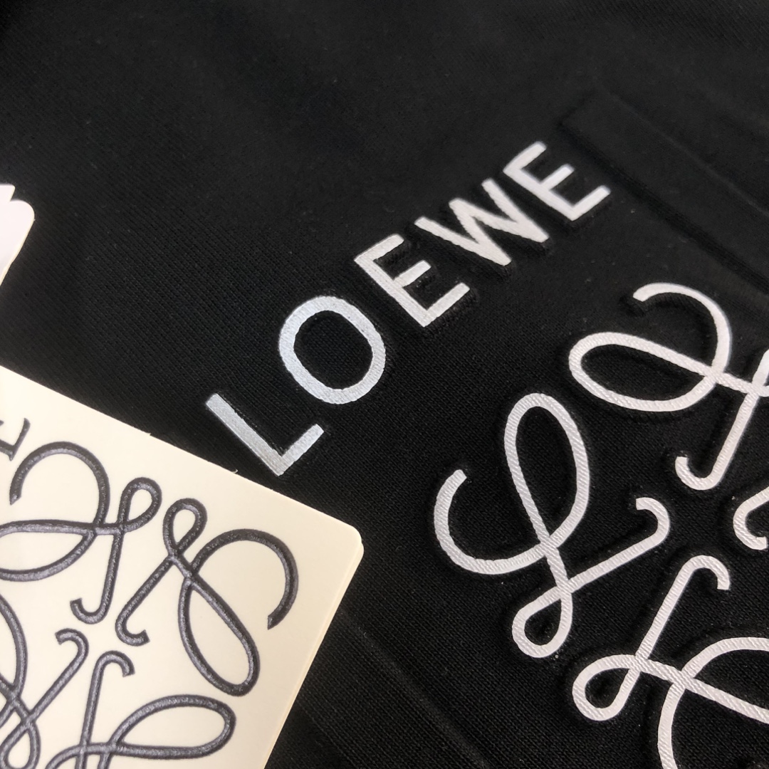 💰85 C✨ LOEWE 罗意威  2024ss春夏新品情侣款圆领T恤🔥 奢华假口袋字母LOGO标识标注👍🏼品牌辨识度超级强 设计感十足👍上身就能体会这款设计带来的年轻与时尚感！整体时尚而有潮流，面料采用客供顶级面料 ，柔软亲肤透气 ，又有很好的挺括 垂感 上身时尚潮流色系，夏季必备单品！
颜色：黑色 白色  蓝色 棕色 玫红色
尺码：XS-S-M-L（宽松版型 下单请报身高体重）