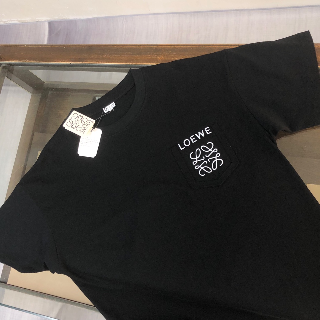 💰85 C✨ LOEWE 罗意威  2024ss春夏新品情侣款圆领T恤🔥 奢华假口袋字母LOGO标识标注👍🏼品牌辨识度超级强 设计感十足👍上身就能体会这款设计带来的年轻与时尚感！整体时尚而有潮流，面料采用客供顶级面料 ，柔软亲肤透气 ，又有很好的挺括 垂感 上身时尚潮流色系，夏季必备单品！
颜色：黑色 白色  蓝色 棕色 玫红色
尺码：XS-S-M-L（宽松版型 下单请报身高体重）