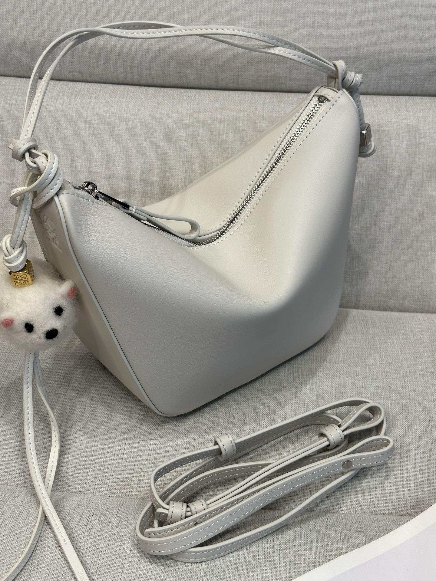 NO:179042,LOw Classic cowhide Hammock hobo handbag Deconstructs the classic handbags that can easily change shapes, retain the representative hammock shape, creating a fashionable and ergonomic hobo handbag. This mini version is made of classic cowhide leather, and knotted cowhide straps can be customized. * Can be shoulder-back, cross-back or hand-held* Zipper closure* Cowhide zipper head* Dice hanging* Herringbone cotton canvas lining* size: 28*17*9.5CM Model c923, special grade Loewe, cowhide19860909LOw 经典牛皮革Hammock hobo手袋 将经典手袋能轻松改变形状的设计进行解构,保留颇具代表性的吊床造型,打造出一款时尚百搭且符合人体工学的hobo手袋.此迷你版本采用经典牛皮革制成,打结牛皮革带子可进行个性化设计.*可肩背、斜背或手提*拉链开合*牛皮革拉链头*骰子挂饰*人字纹棉质帆布衬里* size:28*17*9.5CM 型号c923,特级罗意威,loewe,cowhide,Bag