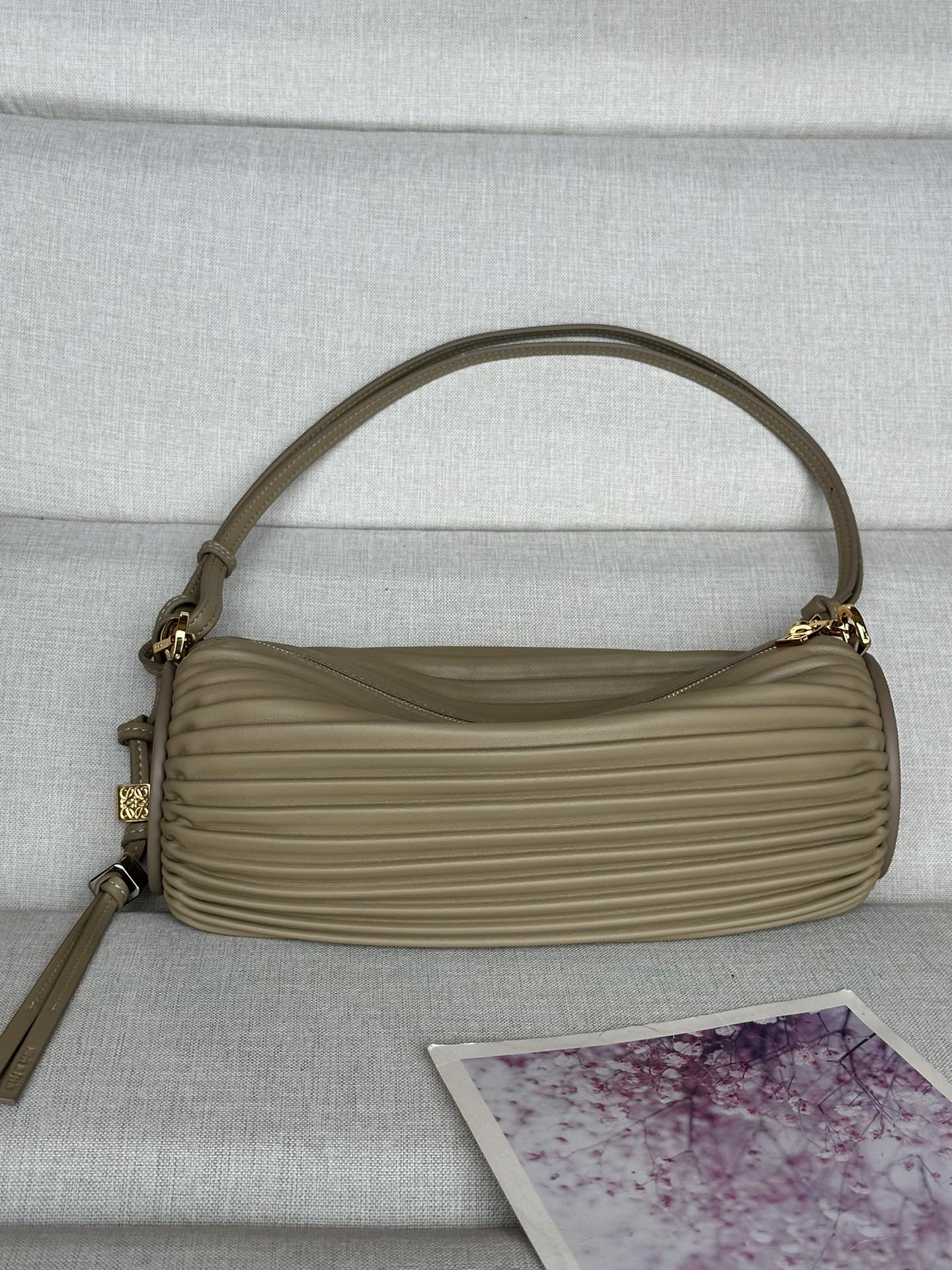 NO:180915,Pleated Napa Leather Bracelet Bag 9751 Color: Khaki Gray This multifunctional tubular bag is made of pleated Napa Sheepskin and can be converted to bracelet. Embossed sheepskin trim at both ends. Removable adjustable straps, snap-buckle fixation Zipper closure with same-stained pull-out Unlined Anagram Embossed 25-10-10 Pleated Napa Leather Bracelet Bag 9751 Color: Clay Green This multifunctional tubular bag is made of pleated Napa Sheepskin and can be converted to bracelet. Embossed sheepskin at both ends. Removable adjustable straps, snap-buckle fixation Zipper closure with same-stained pull-out Unlined Anagram Embossed 25-10-10, Extra Loewe, bracelet, sheepskin19860909褶皱纳帕皮革手链小包 9751 颜色: 卡其灰 这款多功能管状小包采用褶皱纳帕羊皮革制成,可转换为手链佩戴. 两端都饰有压纹羊皮革饰板. 可拆卸可调节带子,按扣固定 拉链开合,带同色拉头 无衬里 Anagram 压纹 25-10-10褶皱纳帕皮革手链小包 9751 颜色: 粘土绿 这款多功能管状小包采用褶皱纳帕羊皮革制成,可转换为手链佩戴. 两端都饰有压纹羊皮革饰板. 可拆卸可调节带子,按扣固定 拉链开合,带同色拉头 无衬里 Anagram 压纹 25-10-10,特级罗意威,loewe,bracelet,sheepskin,Bag