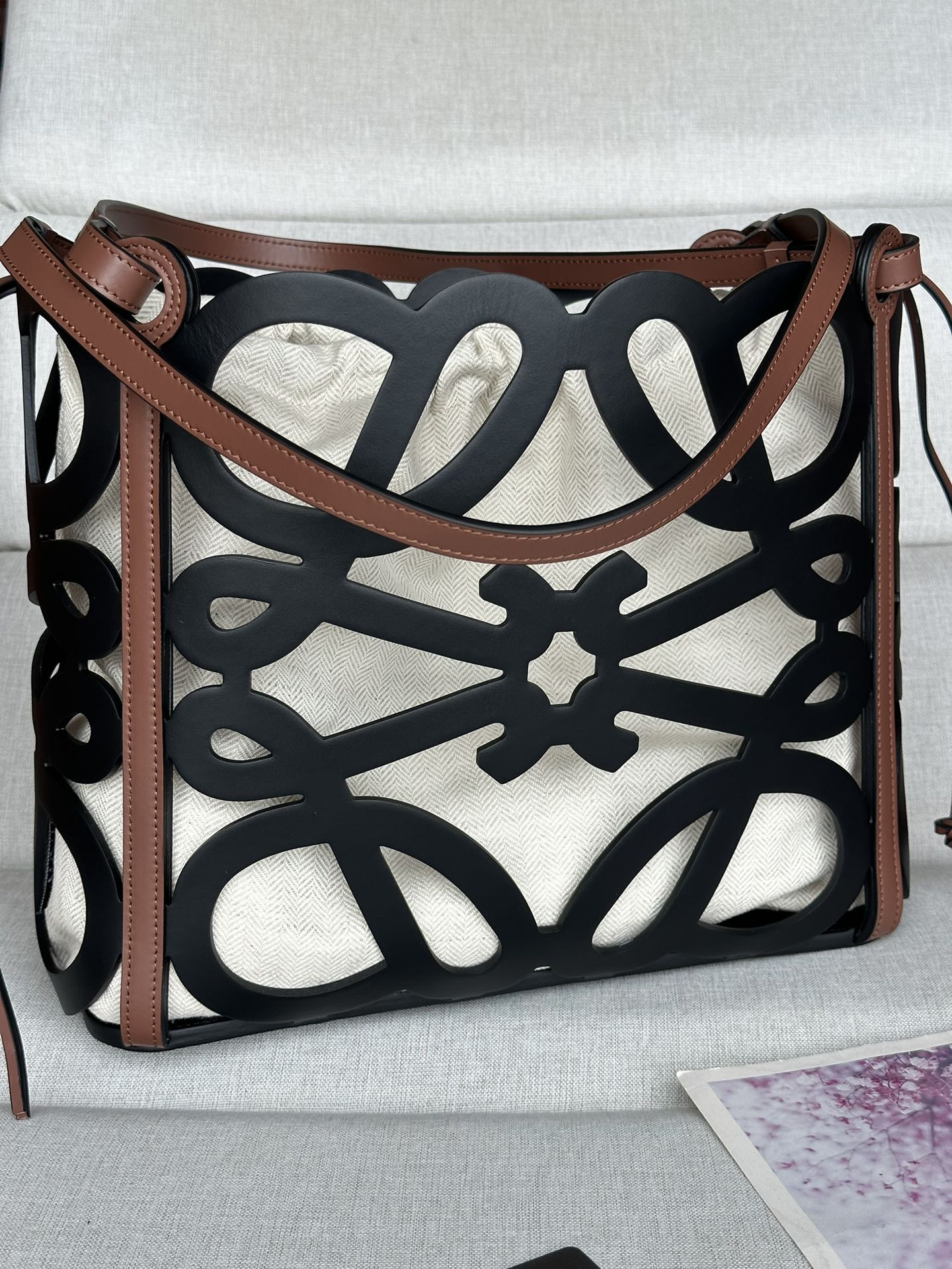 NO:181817,Cowhide leather hollow Anagram Tote handbag really grows on my aesthetics, with large hollow black logo, built-in linen inner bag, and thin ropes that can be retracted on both sides. The back of the armpit is not a problem at all. Cool and cool cool. This multi-functional, versatile casual capacity is touching and also has a fashionable Tote handbag made of Anagram pattern hollow cowhide, and is equipped with cowhide leather handles and herringbone cotton canvas belt inner bag shoulder or top handle carrying * cowhide leather drawstring Size 32CM~27CM~11CM Model number 10678 Color black, special grade Loewe, cowhide19860909牛皮革镂空 Anagram Tote 手袋真的长在我的审美上,镂空黑色大logo,内置麻质内袋,两边有可以收缩的细绳,腋下背完全不是问题酷帅酷帅,这款多功能 ,百搭休闲容量感人的同时还带着时尚感Tote 手袋采用 Anagram 图案镂空牛皮革制成,并配有牛皮革提手和人字形棉帆布束带内袋肩挎或顶部提手携带*牛皮革抽绳 尺寸32CM~27CM~11CM 款号10678 颜色黑色,特级罗意威,loewe,cowhide,Bag