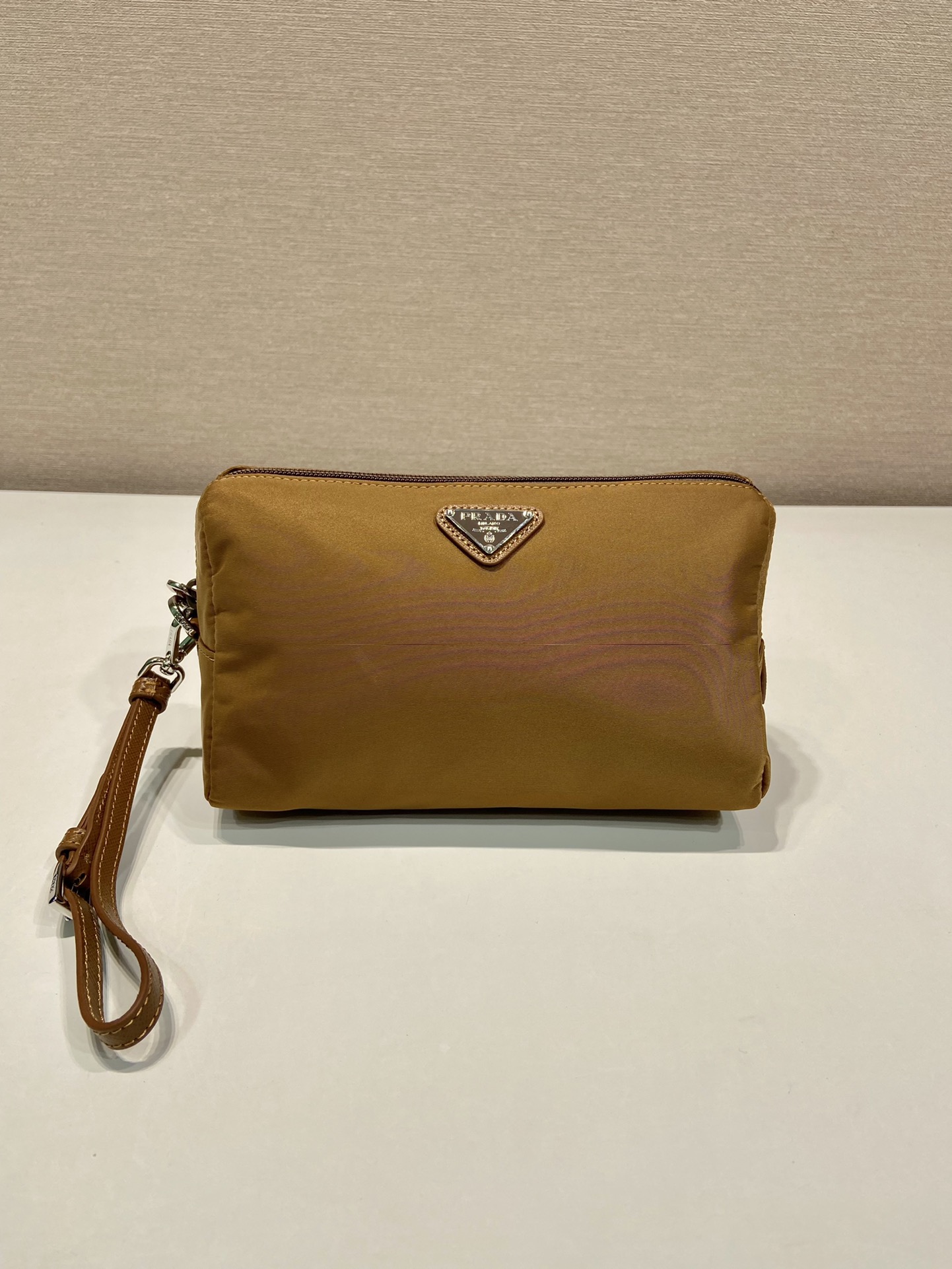 P Family New Handbag 1NS693 Silver Label. This toiletry bag features imported waterproof nylon fabric, premium hardware, logo lining, and a detachable leather wrist strap. Zip closure with one interior zip pocket. Unisex, lightweight, and practical. Size: 20 x 11.5 x 9 cm. 007380 image 1