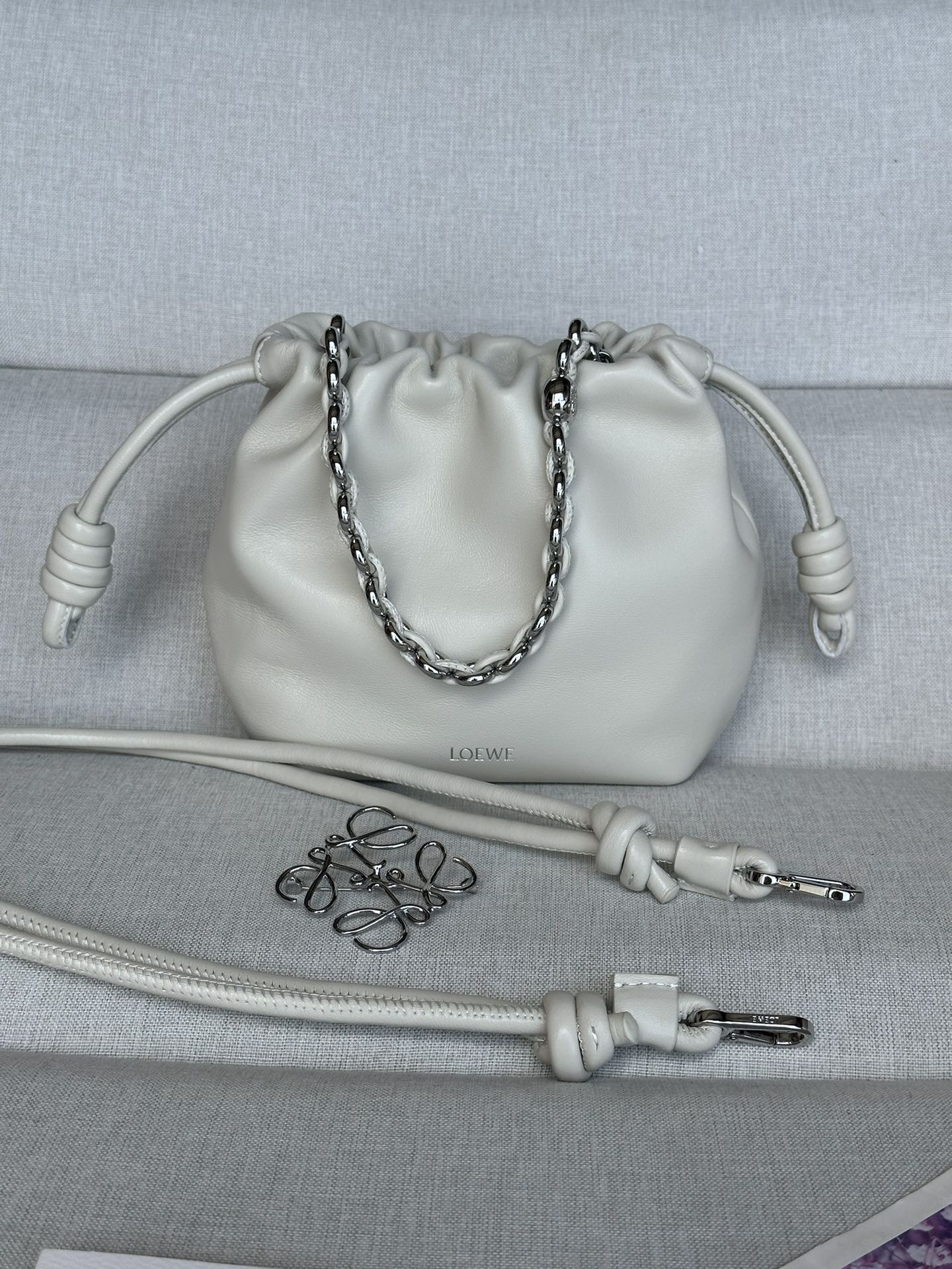 NO:181702,Genuine Grade Original Leather Version Salt White Model 1773 23-17-5.5 (with extended leather straps for metal chains) Mini Napa Sheepskin Flamenco Clutch The Flamenco Clutch released in the 1870s is tightened with a drawstring and tied with the signature coiled knot. Flamenco Purse has been cleverly redesigned to create a soft and sensual draping design with delicate knots and pleated tops. This version is made of soft Napa Sheepskin. Crossbody or shoulder Removable adjustable shoulder straps Low-key magnetic buckle closure Suede lining Material: Sheepskin Weight: 0.2 kg, Superior Loewe, handbag, sheepskin19860909正品级 原厂皮版本 盐白色 型號1773 23-17-5.5(配套金屬鏈條加长皮肩帶） 迷你纳帕羊皮革 Flamenco 手拿包 十九世纪七十年代发布的 Flamenco 手拿包,采用拉绳收紧,并打上标志性的盘绕结.Flamenco Purse 经过巧妙的重新设计,以纤巧的绳结和褶皱顶部打造柔软感性的垂坠设计.此版本采用柔软纳帕羊皮革制成. 可斜挎或肩背 可拆卸可调节肩带 低调的磁扣开合 绒面革衬里 材质:羊皮革 重量:0.2 kg,特级罗意威,loewe,handbag,sheepskin,Bag