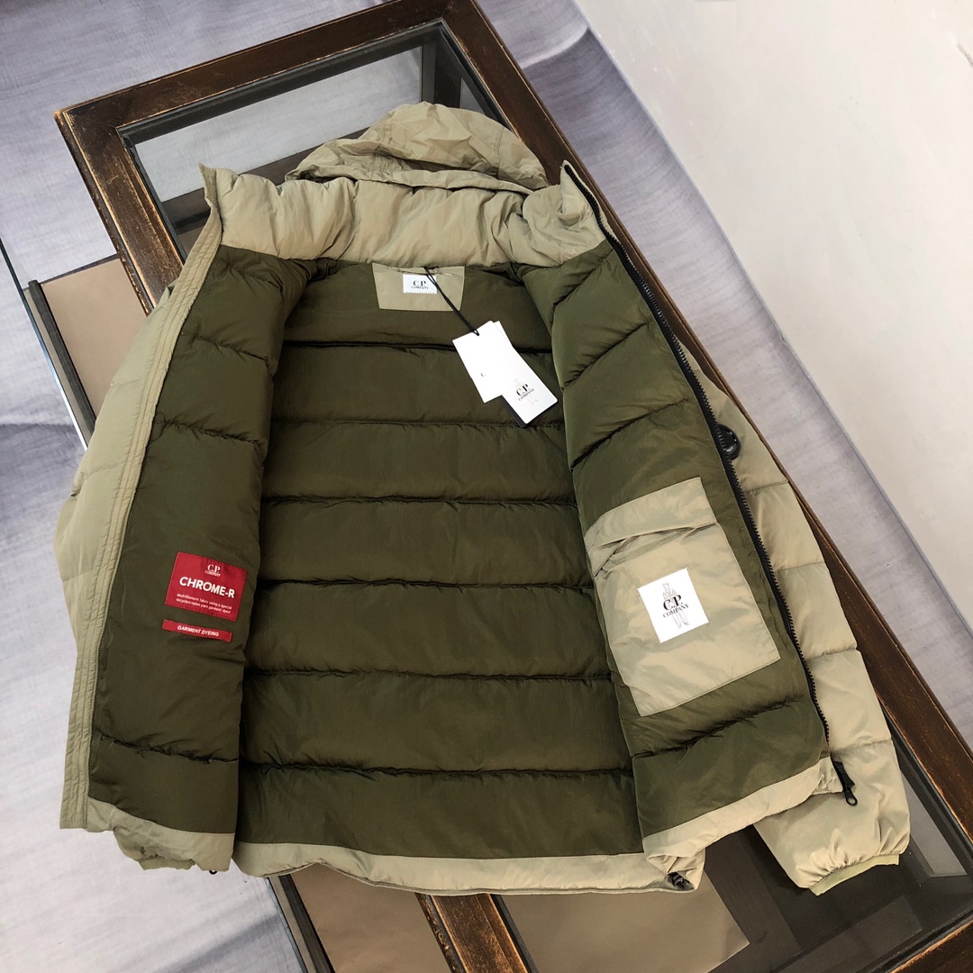 p565.00 CP.COMPANY 新款专柜同步，CP经典羽绒服，90进口羽绒 特殊高密记忆面料原厂染色防水，具备透气且防风功能 上身体感保温舒适度极好  简洁大方的设计 深受户外旅游爱好人士偏爱 也适合平时商务穿着的百搭款 所有辅料原版定制 实物拍照 现货供应  
颜色：黑色 卡其色 橘色
尺码：M-L-XL-XXL

