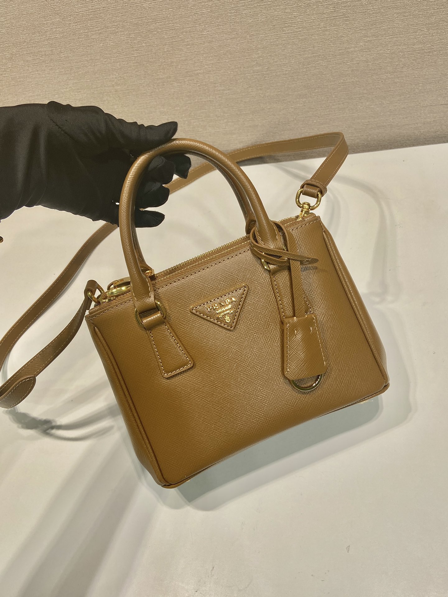 🎉mini杀手🎉1BA906，这款Galleria手袋采用标志性的Saffiano皮革制作，配有一条可拆