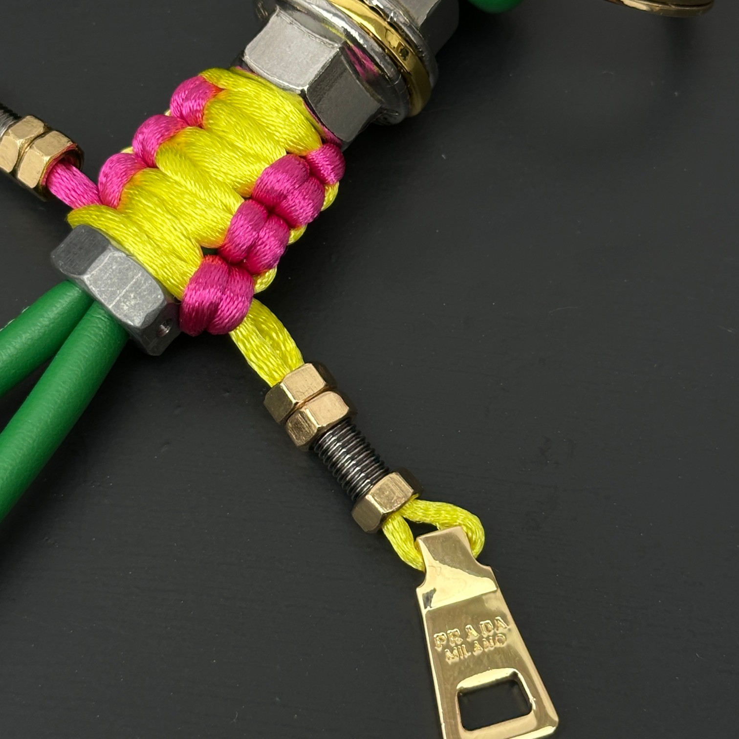 新款🌟这款钥匙扣呈现 Saffiano 牛皮革手工编织富有辨识度的十字纹理，饰有标志性的涂珐琅金属徽标。