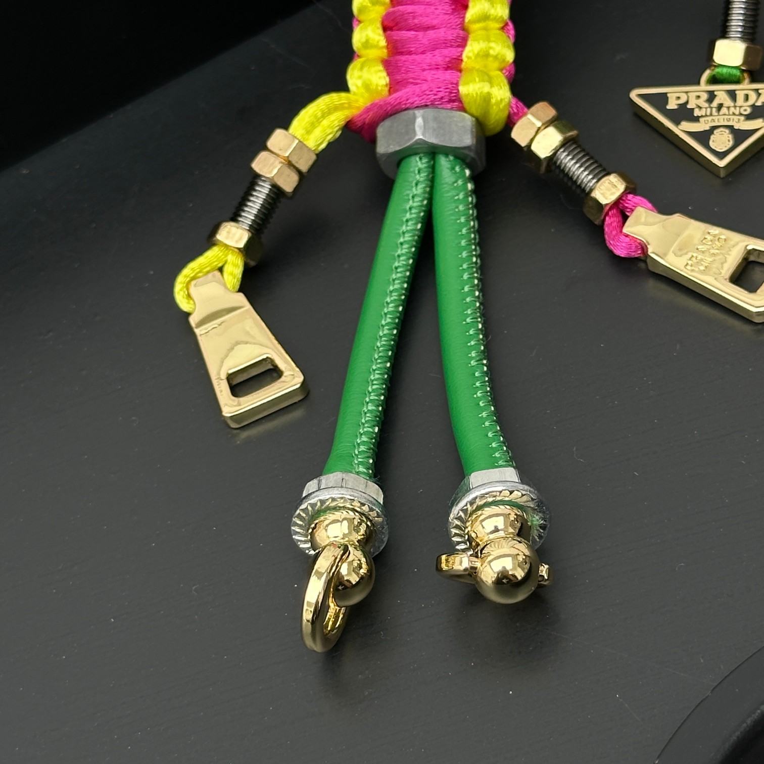 新款🌟这款钥匙扣呈现 Saffiano 牛皮革手工编织富有辨识度的十字纹理，饰有标志性的涂珐琅金属徽标。