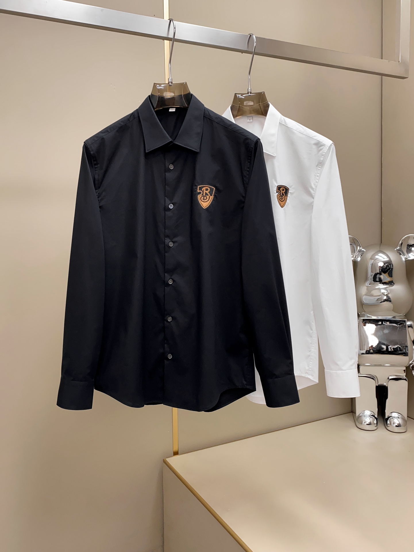 NO:428539,.BUR Burberry Embroidered Shield New Product Men's High-end Fashion High-Stack Cotton Fabric Logo Embroidered Men's Small Point Collar Business Casual Long Sleeve Shirt is a soul-style decoration, quite fashionable and full of British accent!  The details show the high-end and luxurious shell button embellishment, paired with a small lapel design, is age-reducing and fashionable, full of vitality and easily highlights the temperament. The upper body effect is capable and neat, and it has both styles. It is a shirt with versatility and practical wearability!  Fabric selection is high-end imported garment high-split cotton fabric, old-fashioned workshop garment process is fixed, weaving and dyeing, extremely luxurious and special materials, all of which are treated with superior craftsmanship, the fabric has extremely high gloss, the mesh structure is delicate and natural, and the comfort and breathability are perfect. The touch experience is self-evident, and the ultimate luxury enjoyment!  The details show the ingenious craftsmanship, the auxiliary materials are all supplied to customers, and the workmanship is extremely rigorous and sophisticated. The whole outline structure continues the basic form of B's ​​house, expressing the simple and atmospheric characteristics in place!  Black and white Size data recommendation: S-XXL (normal version) S: Shoulder width 44cm-bust 99cm-length 74cm-sleeve length 63 M: Shoulder width 45cm-bust 103cm-length 75cm-sleeve length 64 L: Shoulder width 46cm-bust 107cm-length 76cm-sleeve length 65 XL: Shoulder width 47cm-bust 111cm-length 77cm-sleeve length 66 XXL: Shoulder width 48cm-bust 115cm-length 78cm-sleeve length 67 Size recommendation (fitting style) Height 174-140 catties, try on M size appropriate!  A boy can choose M code within 140 catties, a L code for 140-155 catties, a XL code for 155-170 catties, and a XXL code for 170-188 catties!  All girls can choose S code!  ,burberry,burberry,shirts,alexander wang19860909.BUR巴宝莉 刺绣盾牌新品男士高端时装款高支棉面料Logo刺绣男士小尖领商务休闲长袖衬衫 属于灵魂式的修饰,颇具时髦感,满满的英伦腔调！ 细节之处尽显高级奢侈感十足的贝壳扣点缀,搭配小翻领设计,减龄又时髦,充满活力且极易凸显出气质感,上身效果干练利落,型格兼具,百搭实穿性极好的一款衬衫！ 面料甄选高级进口成衣高支棉面料,老牌工坊成衣工序定织定染,极为奢华特殊的材质,面料属性皆为上乘工艺处理,面料光泽度极高,网眼结构细腻自然,舒适性与透气性完美兼备,触感体验不言而喻,奢华极致享受！细节之处尽显匠心工艺,辅料皆为客供,做工极为严谨考究,通体的轮廓构造延续了B家基础形态,将简约大气的特征表现到位！ 黑色和白色 尺码数据推荐: S一XXL码（正常版） S码: 肩宽44cm-胸围99cm-衣长74cm-袖长63 M码: 肩宽45cm-胸围103cm-衣长75cm-袖长64 L码: 肩宽46cm-胸围107cm-衣长76cm-袖长65 XL码: 肩宽47cm-胸围111cm-衣长77cm-袖长66 XXL码: 肩宽48cm-胸围115cm-衣长78cm-袖长67 尺码推荐（合身版型） 身高174-140斤,试穿M码合适！ 男生体重140斤以内选择M码,140-155斤选择L码,155-170斤选择XL码,170-188斤选择XXL码！ 女生全部选择S码即可！,,burberry,burberry,shirts,alexander wang,Men's clothing