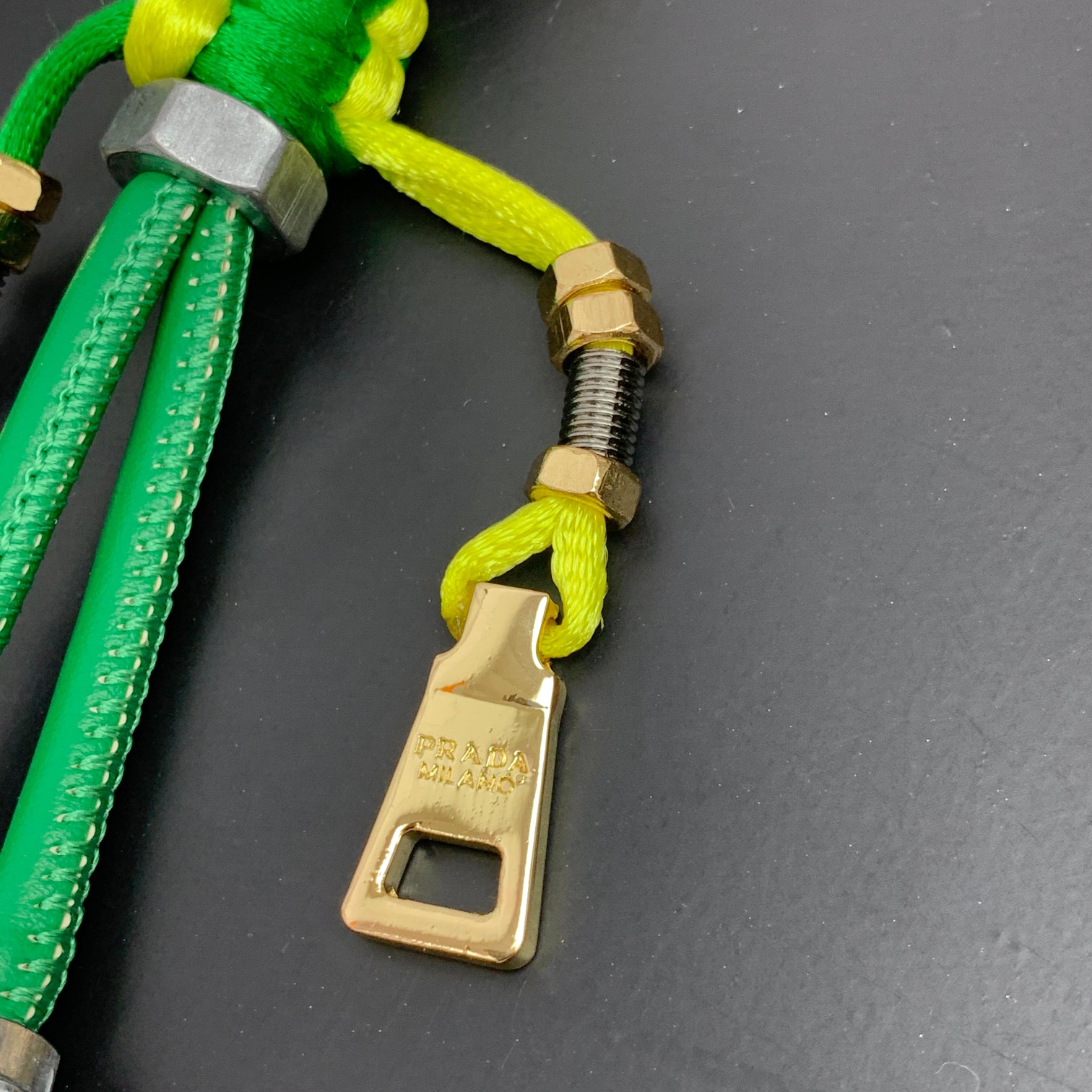 新款🌟这款钥匙扣呈现 Saffiano 牛皮革手工编织富有辨识度的十字纹理，饰有标志性的涂珐琅金属徽标。