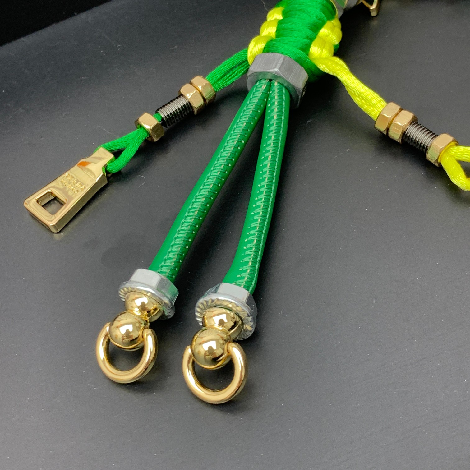 新款🌟这款钥匙扣呈现 Saffiano 牛皮革手工编织富有辨识度的十字纹理，饰有标志性的涂珐琅金属徽标。