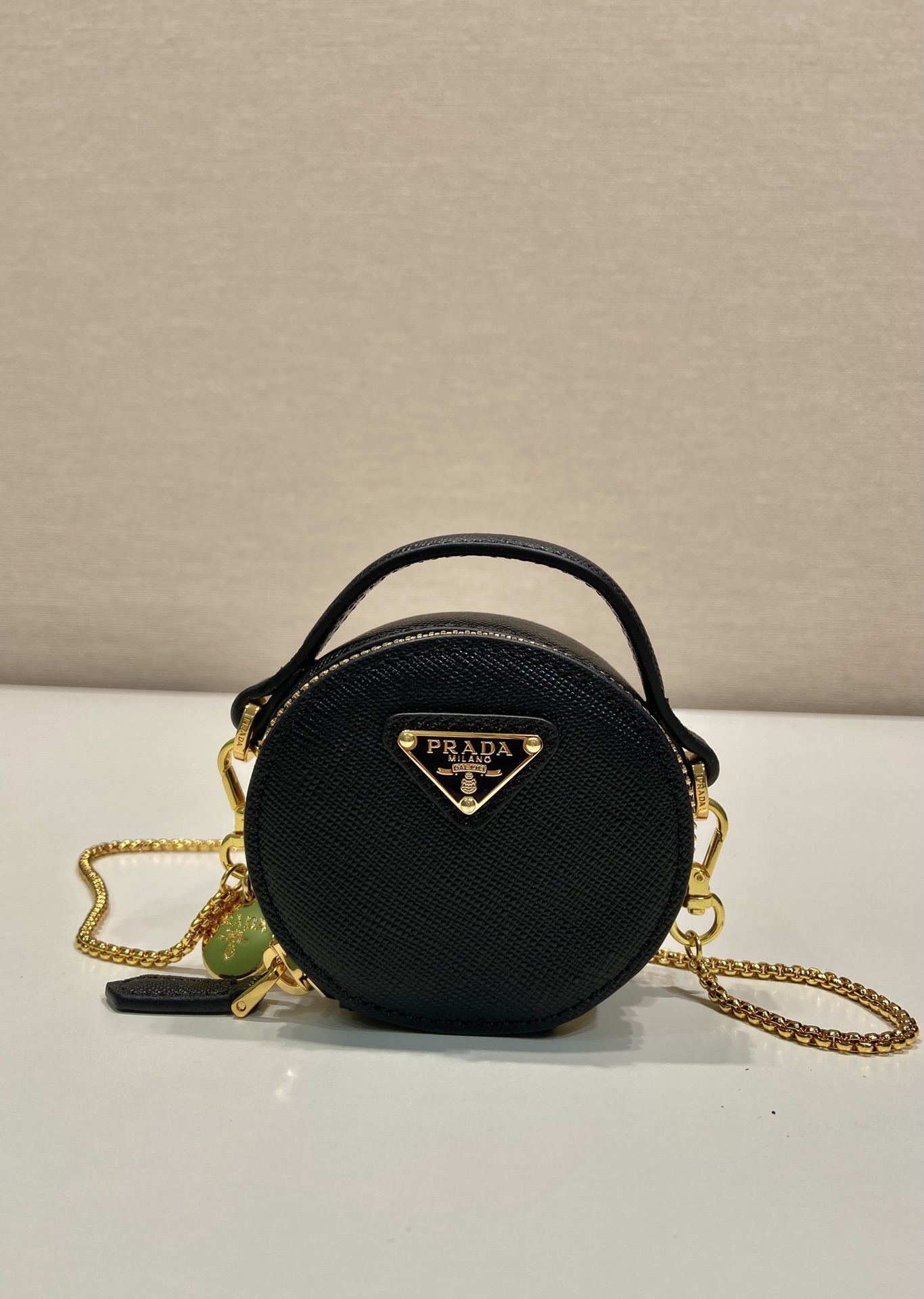 💰480🎉十字纹小圆包🎉1NR023🎉🎉
这款圆形迷你小包展现出现代而精致的廓形，采用十字纹牛皮，饰有闪闪发光的金属五金配件，搭配优雅的可拆式链条肩带，太可爱了😍上身效果非常吸眼，可仙可酷，难道你不心动😗😗，美妞们，赶紧入手吧，太美太可爱了😋😋
长8x高8x底3.5cm🎉🎉🎉👏👏👏