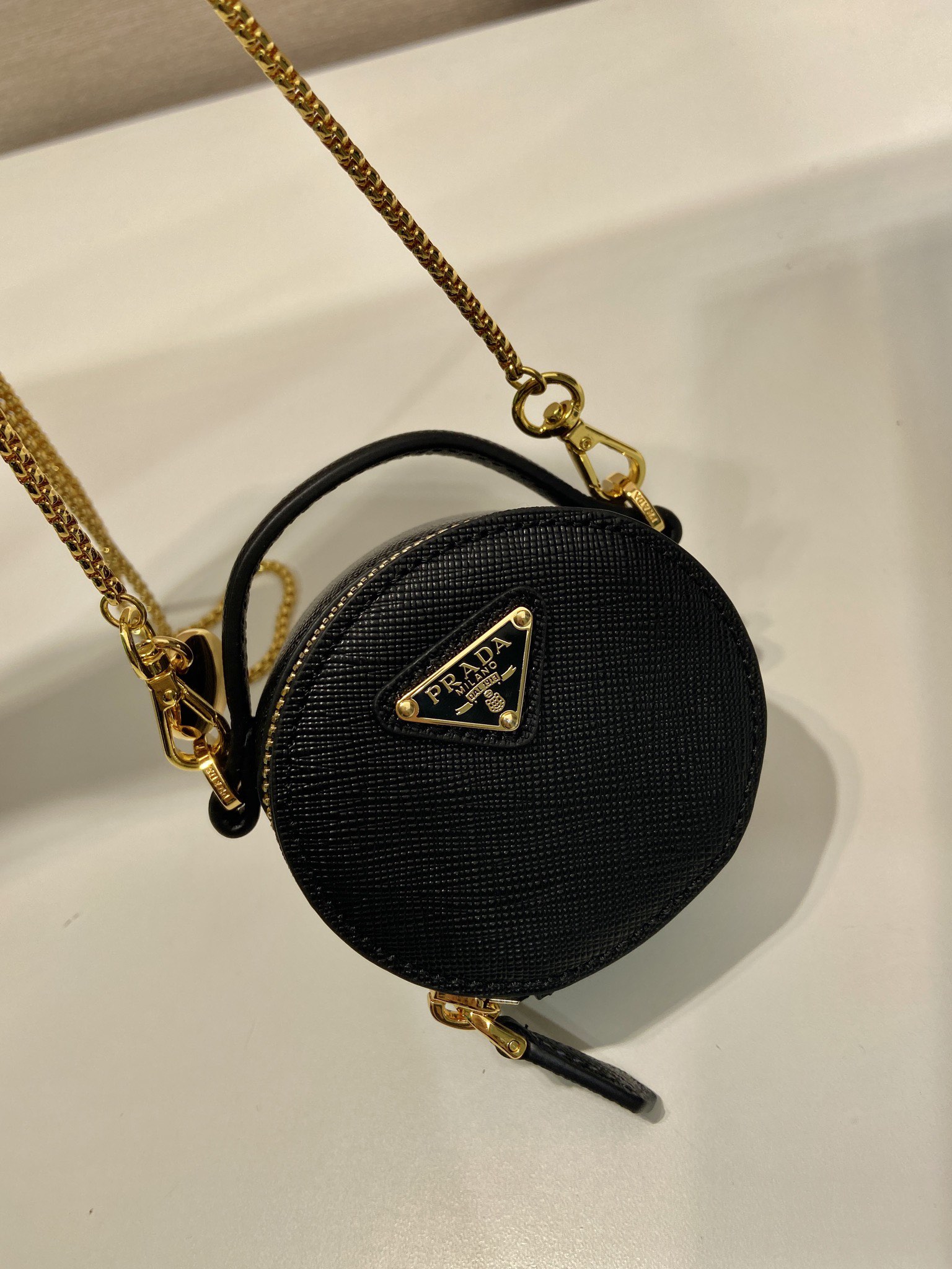 💰480🎉十字纹小圆包🎉1NR023🎉🎉
这款圆形迷你小包展现出现代而精致的廓形，采用十字纹牛皮，饰有闪闪发光的金属五金配件，搭配优雅的可拆式链条肩带，太可爱了😍上身效果非常吸眼，可仙可酷，难道你不心动😗😗，美妞们，赶紧入手吧，太美太可爱了😋😋
长8x高8x底3.5cm🎉🎉🎉👏👏👏