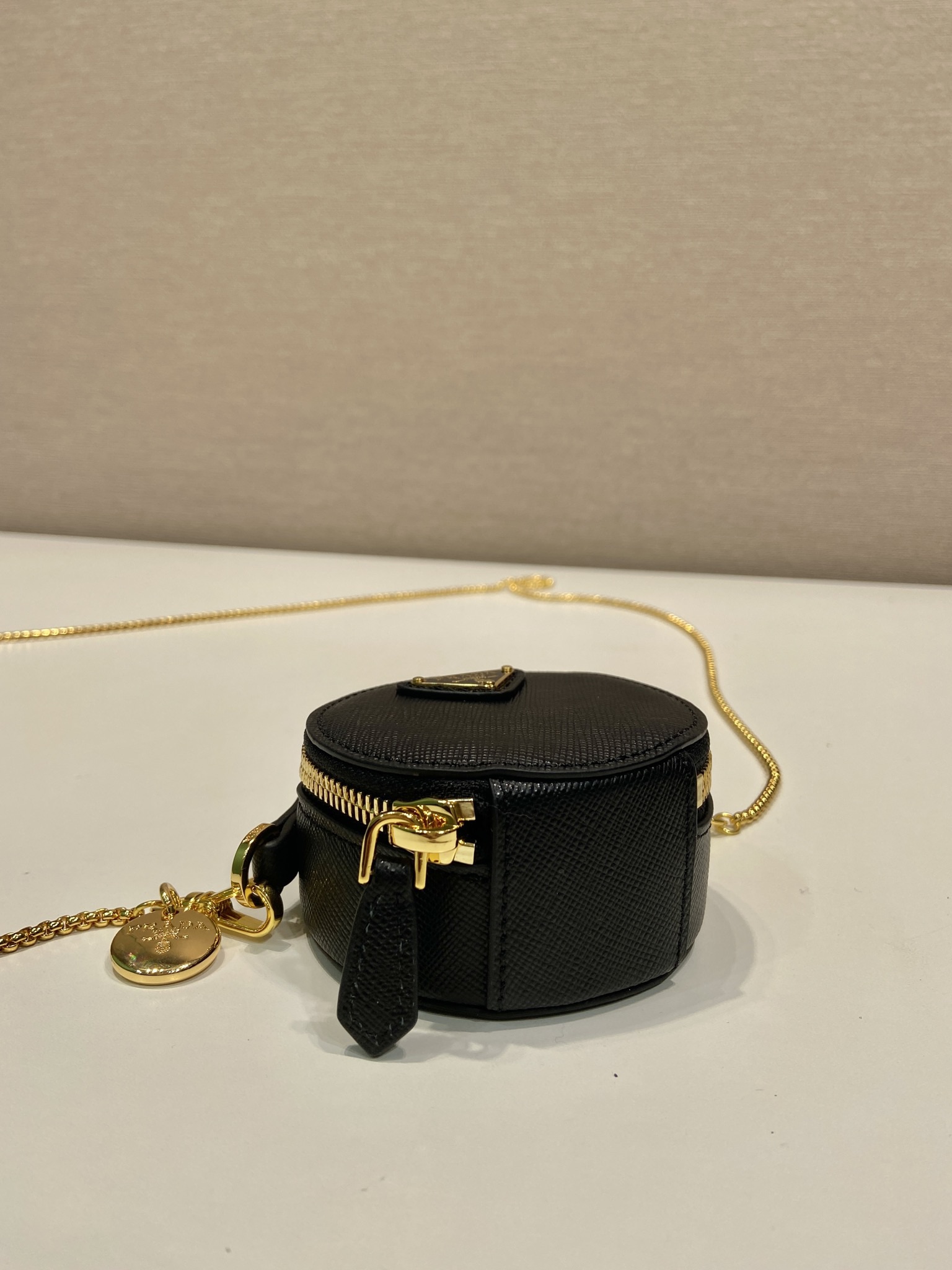 💰480🎉十字纹小圆包🎉1NR023🎉🎉
这款圆形迷你小包展现出现代而精致的廓形，采用十字纹牛皮，饰有闪闪发光的金属五金配件，搭配优雅的可拆式链条肩带，太可爱了😍上身效果非常吸眼，可仙可酷，难道你不心动😗😗，美妞们，赶紧入手吧，太美太可爱了😋😋
长8x高8x底3.5cm🎉🎉🎉👏👏👏