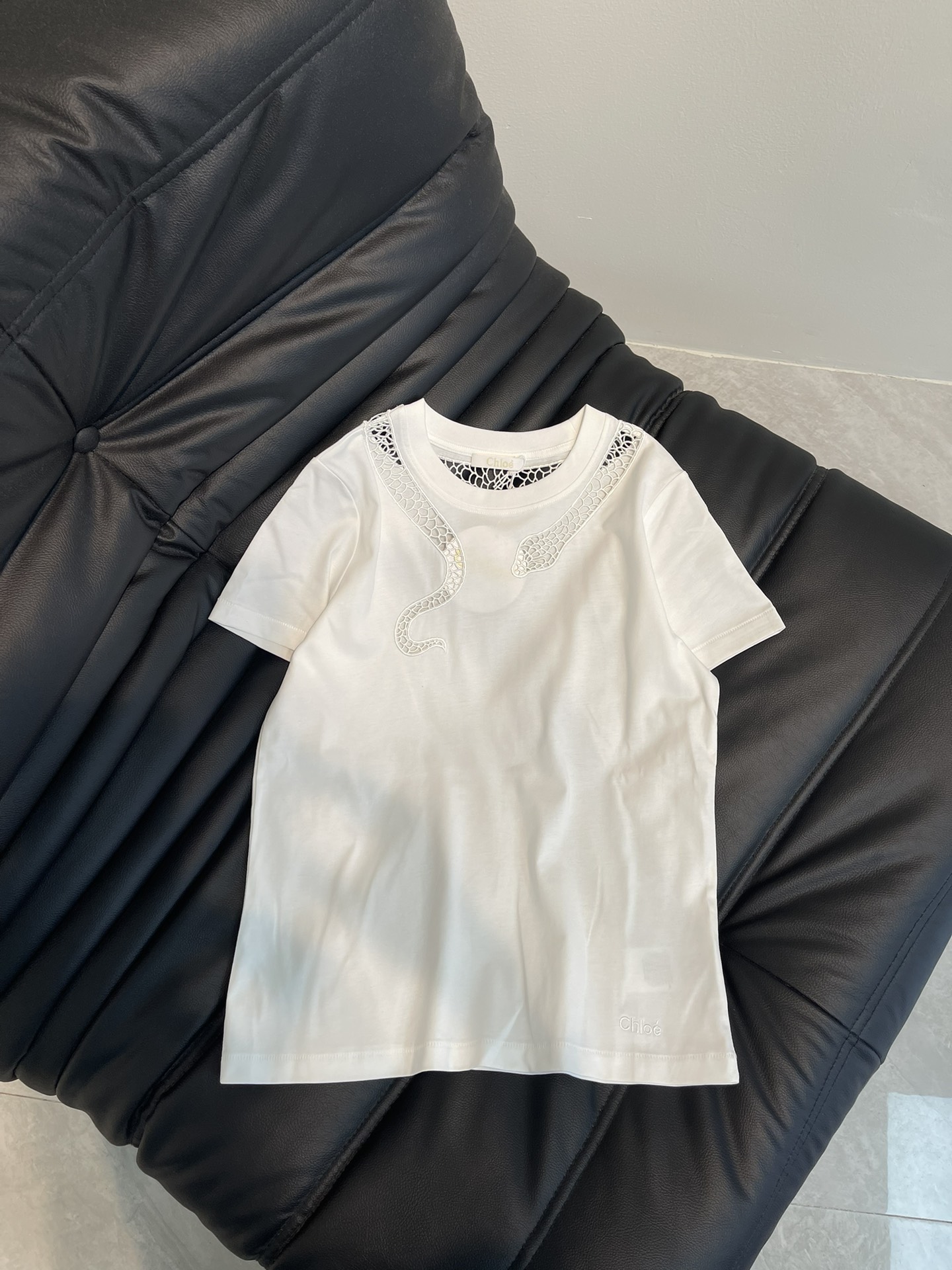 NO:317083,Chlo*25 spring and summer new round neck embroidered hollow short-sleeved T-shirt custom YB twill cotton material breathable and comfortable, full texture. Regular short-sleeved T-shirt cut highlights the brand style. Made of gram-weight pure cotton, slightly elastic, presents a slim visual effect. The neckline uses hollow design to outline snake-shaped patterns and echoes the atmosphere of the New Year zodiac. Fashionable and high-end feeling immediately appears. Red and white refreshing and high-end dark green unique charm. Letter embroidery embroidery embroidery embroidery hem. It is very eye-catching to create a personal style. Slack and fashionable. SML, chloe, T-shirt,tees, t-shirt,alexander wang19860909Chlo*25春夏新品圆领刺绣镂空短袖T恤 定制YB斜纹全棉材质 透气舒适 质感十足 常规短袖T恤裁剪 凸显品牌格调 采用克重纯棉制成 略带有弹力 呈现显瘦视觉效果 领口利用镂空设计勾勒出蛇形图案 同时呼应新年生肖氛围感 时尚高级感立现 红白清爽高级 墨绿独特魅力 字母刺绣点缀衣摆 十足亮眼 打造个性风格 松弛时髦 单穿内搭都出彩时髦 SML,,chloe,T-shirt,tees，t-shirt,alexander wang,Women's clothing