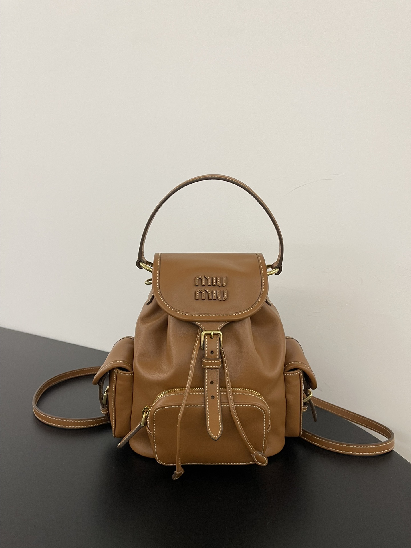 P930 Mochila pequeña caramelo Miumiu 缪缪25ss muy popular en primavera, cuero de becerro marrón importado con letras miu,…