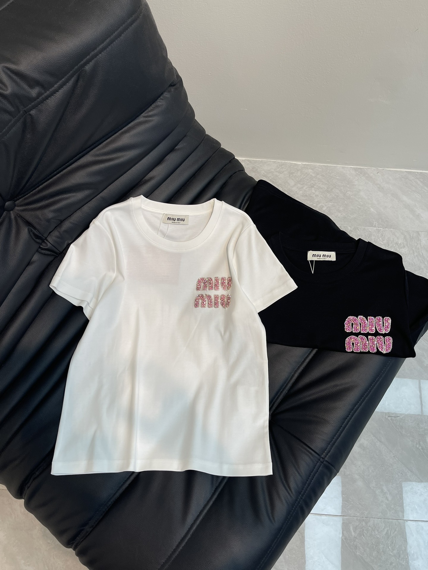 NO:310205,Miumi*25 spring and summer new round neck bead embroidered short-sleeved T-shirt custom YB twill cotton material breathable and comfortable, full texture Slim short-sleeved T-shirt cut highlights the brand style Made of gram-weight pure cotton with a slight elasticity Presents a slim visual effect Pink bead embroidery craft on the chest Presents a three-dimensional flower letter pattern The playful and fashionable feeling of the Miao series The classic black and white color scheme creates a personal style Fashionable and age-reducing The inner wear is brilliant and fashionable SML,,miumiu, T-shirt,tees, t-shirt,alexander wang19860909Miumi*25春夏新款圆领钉珠刺绣短袖T恤 定制YB斜纹全棉材质 透气舒适 质感十足 修身短袖T恤裁剪 凸显品牌格调 采用克重纯棉制成 略带有弹力 呈现显瘦视觉效果 胸前粉色钉珠刺绣工艺 呈现出立体感花体字母图案 缪系俏皮时尚感立现 黑白经典配色打造个性风格 时髦减龄 单穿内搭都出彩时髦 SML,,miumiu,T-shirt,tees，t-shirt,alexander wang,Women's clothing