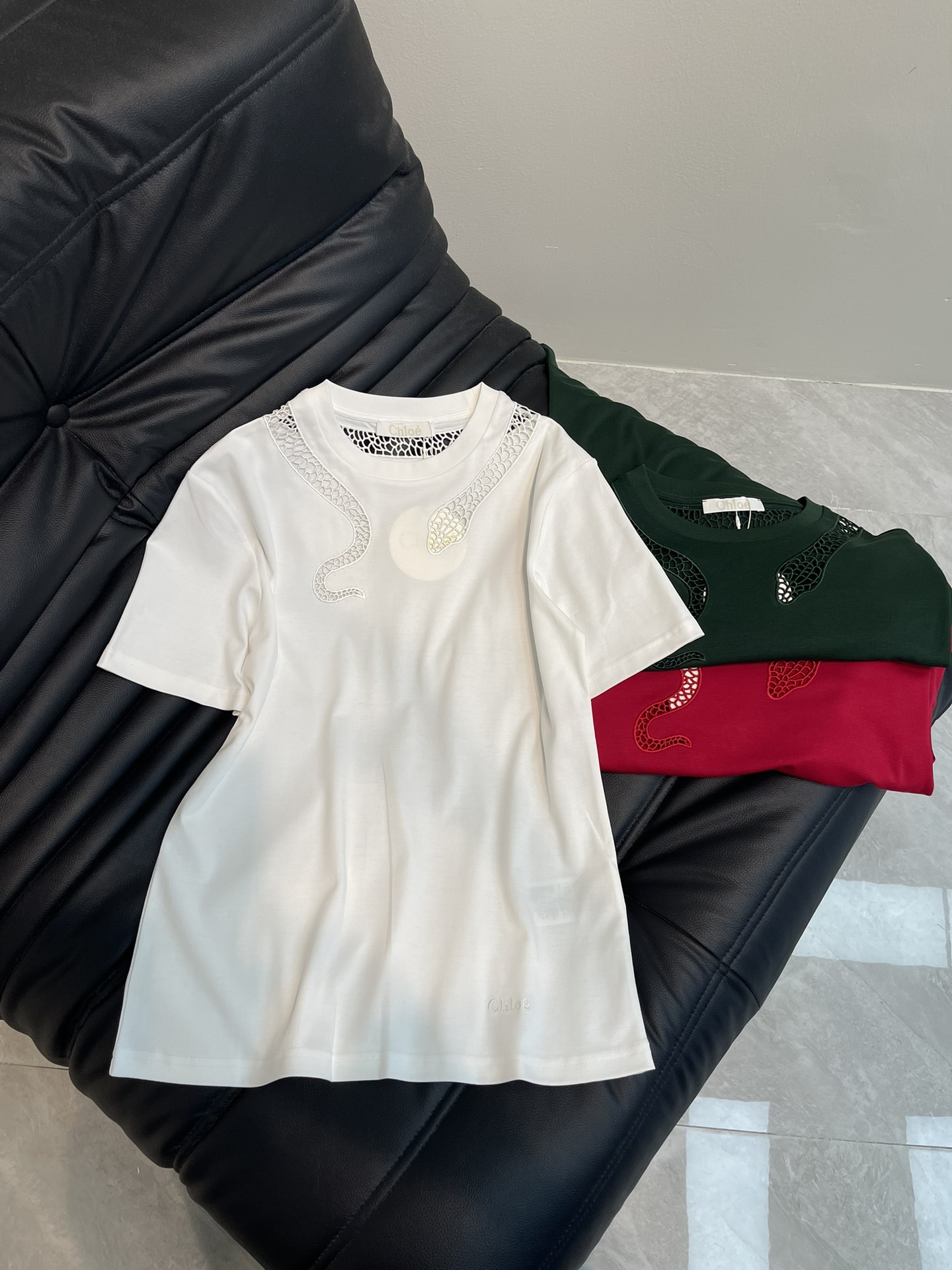 NO:311169,Chlo*25 spring and summer new round neck embroidered hollow short-sleeved T-shirt custom YB twill cotton material breathable and comfortable, full texture. Regular short-sleeved T-shirt cut highlights the brand style. Made of gram-weight pure cotton, slightly elastic, presents a slim visual effect. The neckline uses hollow design to outline snake-shaped patterns and echoes the atmosphere of the New Year zodiac. Fashionable and high-end feeling immediately appears. Red and white refreshing and high-end dark green unique charm. Letter embroidery embroidery embroidery embroidery embroidery hem. It is very eye-catching to create a personal style. Slack and fashionable. SML AA2,,chloe,T-shirt,tees,t-shirt,alexander wang19860909Chlo*25春夏新品圆领刺绣镂空短袖T恤 定制YB斜纹全棉材质 透气舒适 质感十足 常规短袖T恤裁剪 凸显品牌格调 采用克重纯棉制成 略带有弹力 呈现显瘦视觉效果 领口利用镂空设计勾勒出蛇形图案 同时呼应新年生肖氛围感 时尚高级感立现 红白清爽高级 墨绿独特魅力 字母刺绣点缀衣摆 十足亮眼 打造个性风格 松弛时髦 单穿内搭都出彩时髦 SML AA2,,chloe,T-shirt,tees，t-shirt,alexander wang,Women's clothing