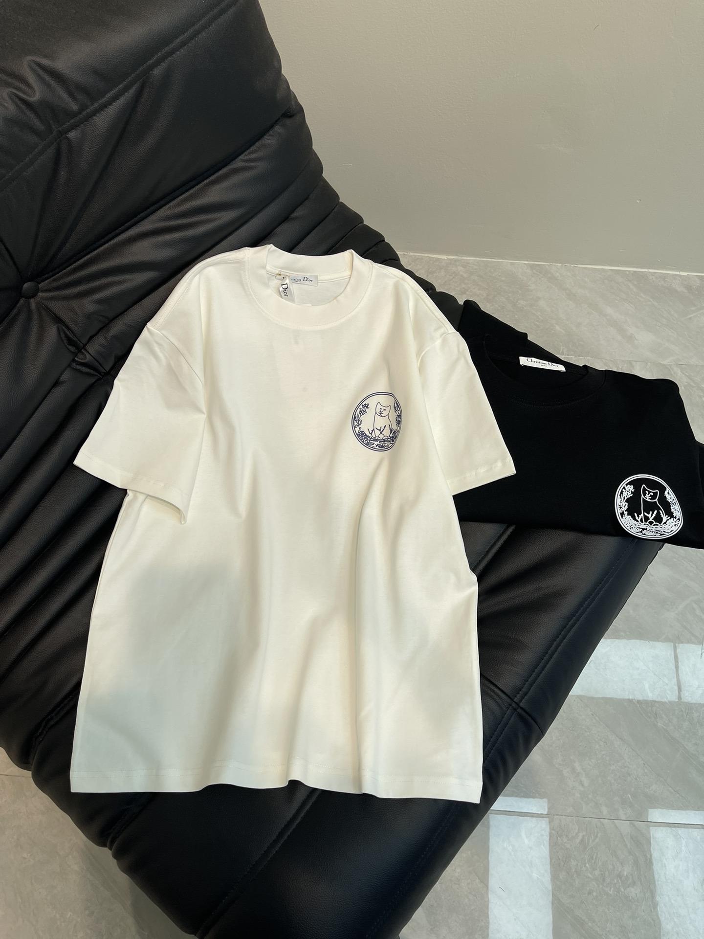 NO:313238,Dio* X Hylton nel25 new cartoon printed short-sleeved T-shirt. Customized cotton fabric, soft and skin-friendly and comfortable. When CD and HYLTON NEL fantasy co-branded, fashion sparks bloom! The brand printed logo is superimposed with cartoon patterns, and the cat-shaped pattern is elegant, adding fun and fashionable feeling. It is surrounded by exquisite floral patterns, which contrasts with the light-colored clothes background, and has rich details. A very simple and atmospheric style. Whether it is the comfort of the upper body, it is incomparable, interpreting your luxury and taste, and creating your fashionable charm. The same style as men and women!  Color white black Size S-XL,dior,T-shirt,tees,t-shirt,alexander wang19860909Dio* X Hylton nel25新款卡通印花短袖T恤.定制全棉面料,面料柔软,亲肤舒适.当CD与HYLTON NEL梦幻联名,时尚火花就此绽放!品牌印花标识叠加卡通图案,猫型图案形态优雅,增添了趣味性和时尚感.周围环绕着精致的花卉图案,与浅色衣服背景形成对比,细节丰富.非常简约大气的一款 无论是上身舒适度都是无可比拟的存在,诠释你的奢华与品位,打造你的时尚风情魅力所在.男女同款！ 颜色白色 黑色 尺码S-XL,,dior,T-shirt,tees，t-shirt,alexander wang,Women's clothing