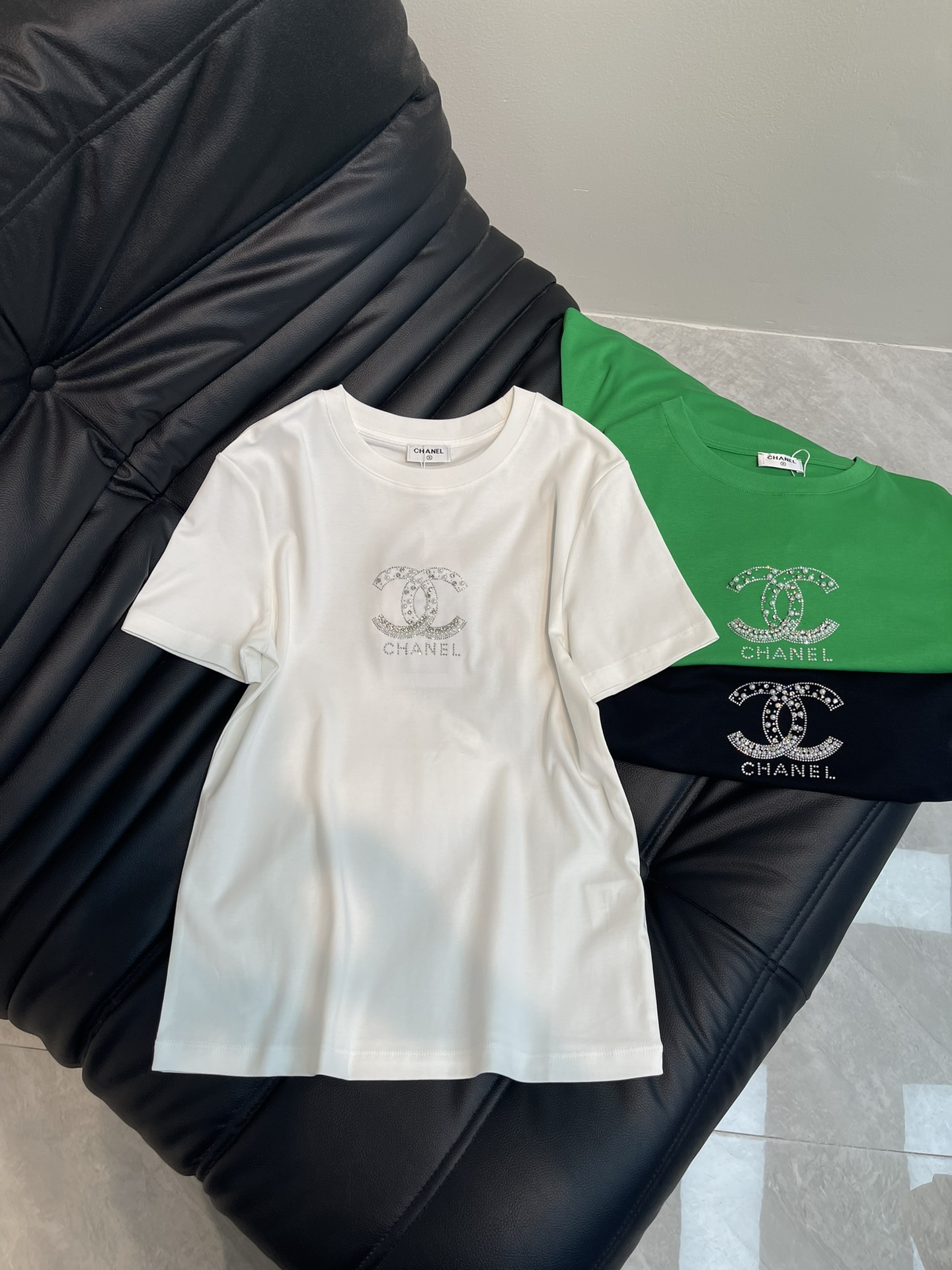 NO:322228,Chane*25 spring and summer new round-neck rhinestone logo short-sleeved T-shirt custom YB native cotton material breathable and comfortable, full texture. Regular T-shirt cutting highlights the brand style. Made of gram-weight pure cotton, slightly elastic, and slim visual effect. Silver-white rhinestones sewn on the chest, presenting a three-dimensional double C pattern. Xiaoxiangjia's fashionable feeling is instantly revealed. Black and white classic grass green color combination creates a personal style. Fashionable and age-reducing. Single wear and inner wear is brilliant and fashionable. SML A,,chanel,chanel,T-shirt,tees,t-shirt,alexander wang19860909Chane*25春夏新款圆领水钻徽标短袖T恤 定制YB原生全棉材质 透气舒适 质感十足 常规T恤裁剪 凸显品牌格调 采用克重纯棉制成 略带有弹力 呈现显瘦视觉效果 胸前缝制银白水钻 呈现出立体双C图案 小香家时尚感立现 黑白经典草绿配色打造个性风格 时髦减龄 单穿内搭都出彩时髦 SML A,,chanel,chanel,T-shirt,tees，t-shirt,alexander wang,Women's clothing