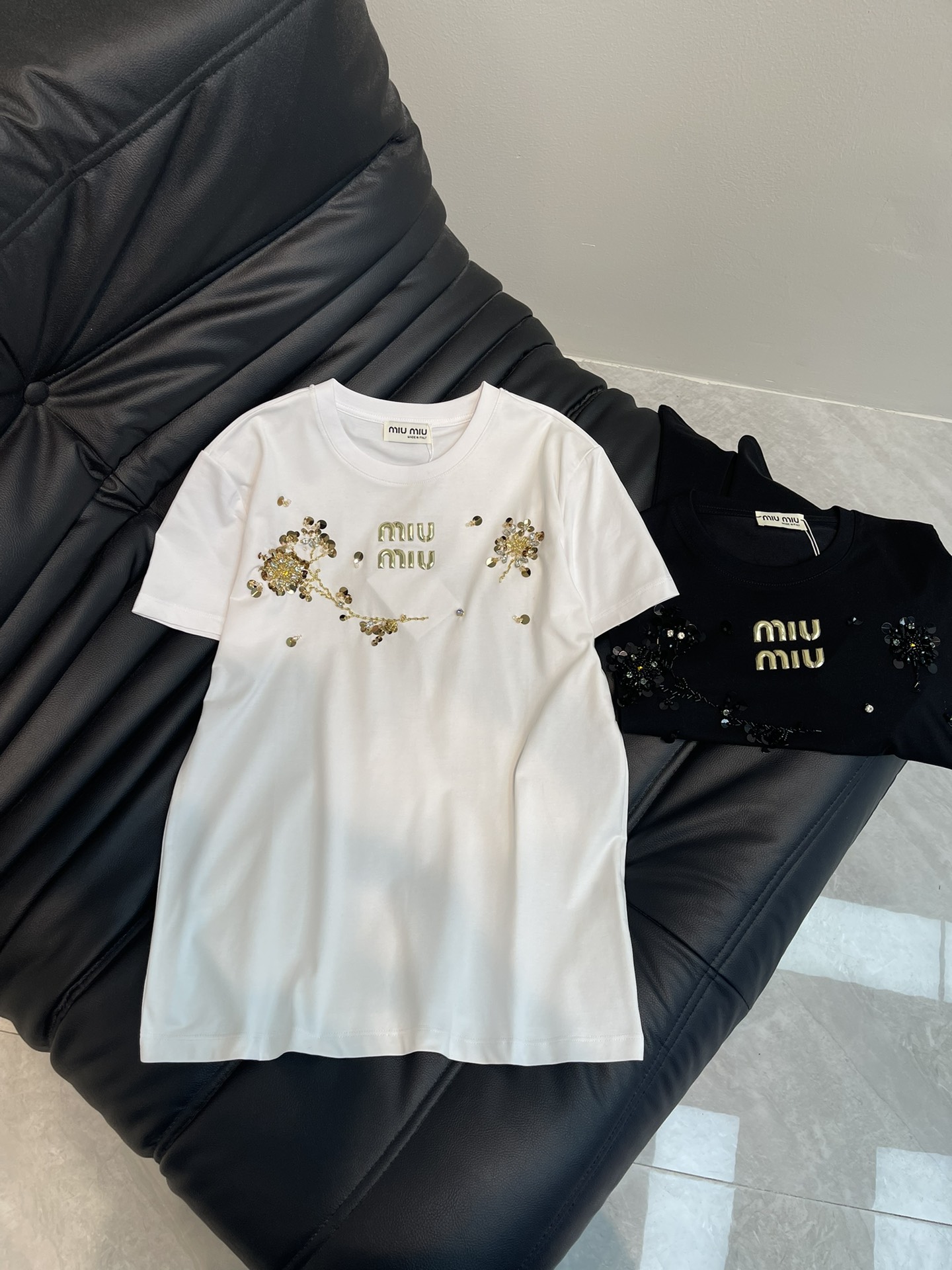 NO:322227,Miumi*25 spring and summer new heavy industry beaded short-sleeved T-shirt custom YB twill cotton material breathable and comfortable, full texture. Regular T-shirt cutting highlights the brand style. Made of gram-weight pure cotton, slightly elastic, and gives a slim visual effect. Asymmetrical hand-sewn nail bead sequins on the chest. Combination molding outlines the flower effect. Combination and three-dimensional reflective logo words on the chest. The upper body is versatile and high-end. Show high-end style. The inner wear is brilliant and fashionable. SML,,miumiu, T-shirt,tees, t-shirt,alexander wang19860909Miumi*25春夏新款重工钉珠短袖T恤 定制YB斜纹全棉材质 透气舒适 质感十足 常规T恤裁剪 凸显品牌格调 采用克重纯棉制成 略带有弹力 呈现显瘦视觉效果 胸前不对称手工缝制钉珠亮片 组合成型勾勒出花朵效果 配合胸前立体反光徽标字样 上身百搭高级 彰显高级格调 单穿内搭都出彩时髦 SML,,miumiu,T-shirt,tees，t-shirt,alexander wang,Women's clothing