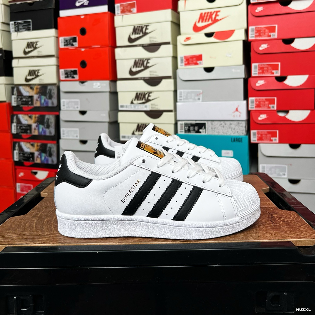 精品实拍YL\n头层皮阿迪达斯 ADIDAS SUPERSTAR 三叶草经典贝壳头系列 新款休闲板鞋潮流男女士运动鞋 。鞋面柔软皮革材质 标志性的贝壳鞋头，锯齿三条纹，简约的线条。就连版型和比例，都在向年的鞋款致敬。可谓“形神兼备”的复刻。无论在哪，无论去哪，你或许都需要这样一双既舒适又时尚的鞋。JQ年问世于篮球场的adidas Superstar，集舒适与时尚于一身。这款经典鞋，缀低调图案，灵感源自公共交通地图。设计简约，旨在伴你出行。心动不如行动，系好鞋带，出发吧。\n\n货号：IH\n码数：-