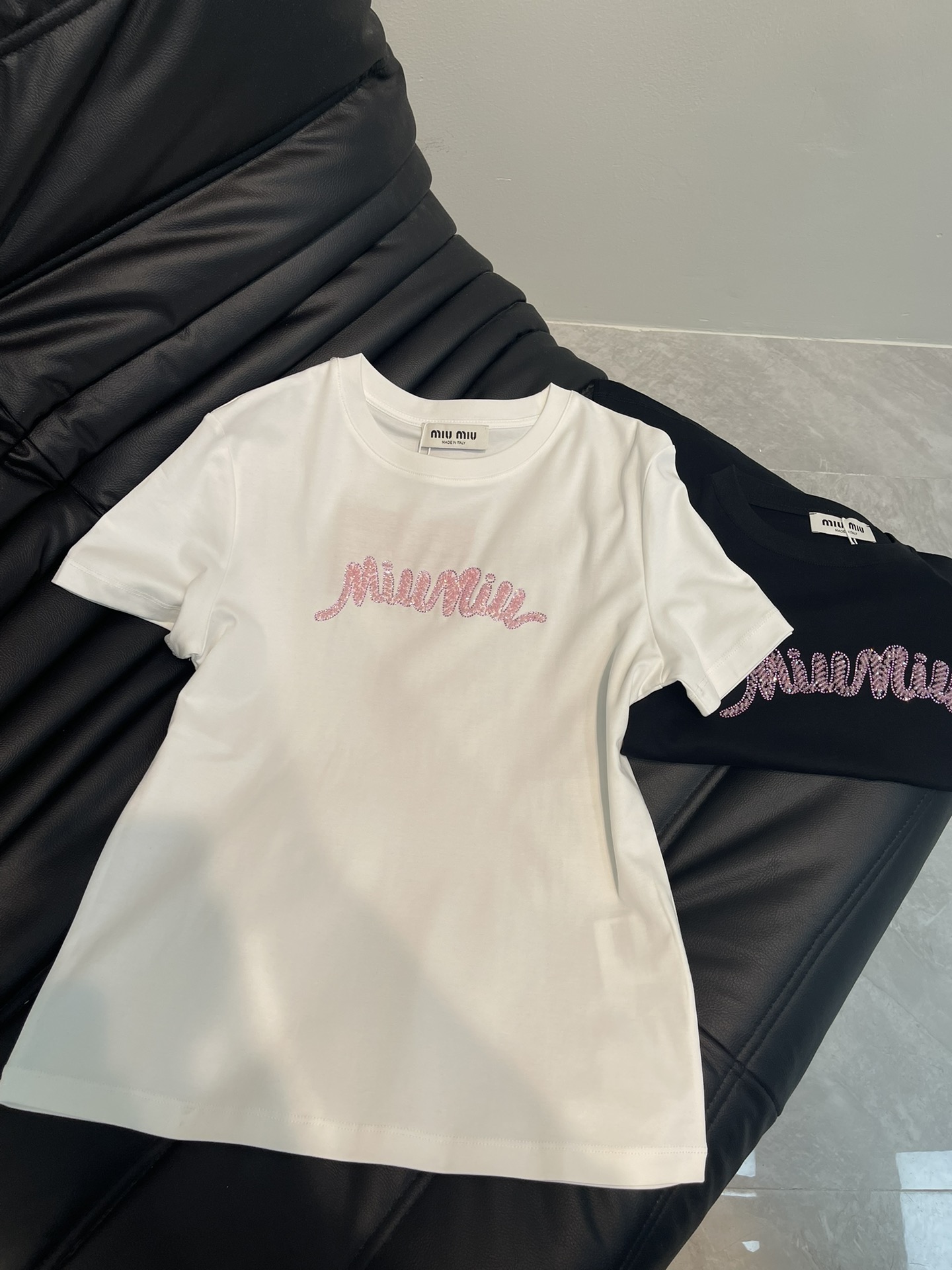 NO:323300,Miumi*25 spring and summer new heavy industry beaded short-sleeved T-shirt custom YB native cotton material breathable and comfortable, full texture. Regular T-shirt cutting highlights the brand style. Made of gram-weight pure cotton, slightly elastic, and slim visual effect. Pink sequin beading craftsmanship on the chest presents a three-dimensional Miao family letter logo pattern. Exquisite and fashionable feeling. Bright color matching creates a personal style. Fashionable and age-reducing. Single wear and stylish inner wear is brilliant and fashionable. SML AA,,miumiu,T-shirt,tees,t-shirt,alexander wang19860909Miumi*25春夏新款重工钉珠短袖T恤 定制YB原生全棉材质 透气舒适 质感十足 常规T恤裁剪 凸显品牌格调 采用克重纯棉制成 略带有弹力 呈现显瘦视觉效果 胸前粉色亮片钉珠工艺 呈现出立体缪家字母徽标图案 精致时尚感立现 亮眼配色打造个性风格 时髦减龄 单穿内搭都出彩时髦 SML AA,,miumiu,T-shirt,tees，t-shirt,alexander wang,Women's clothing