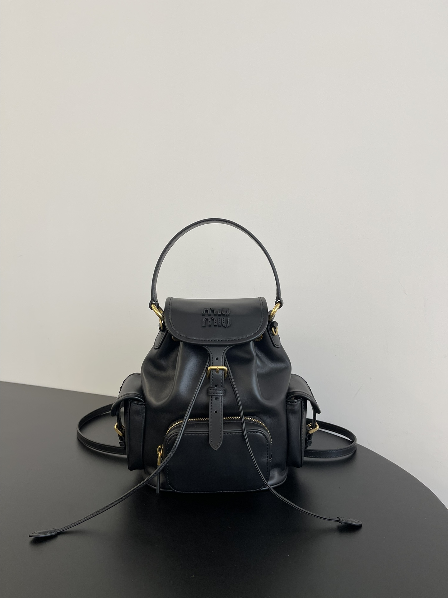 P930 Mochila pequeña negra Miumiu 缪缪25ss muy popular en primavera, cuero de becerro marrón importado con letras miu, de…