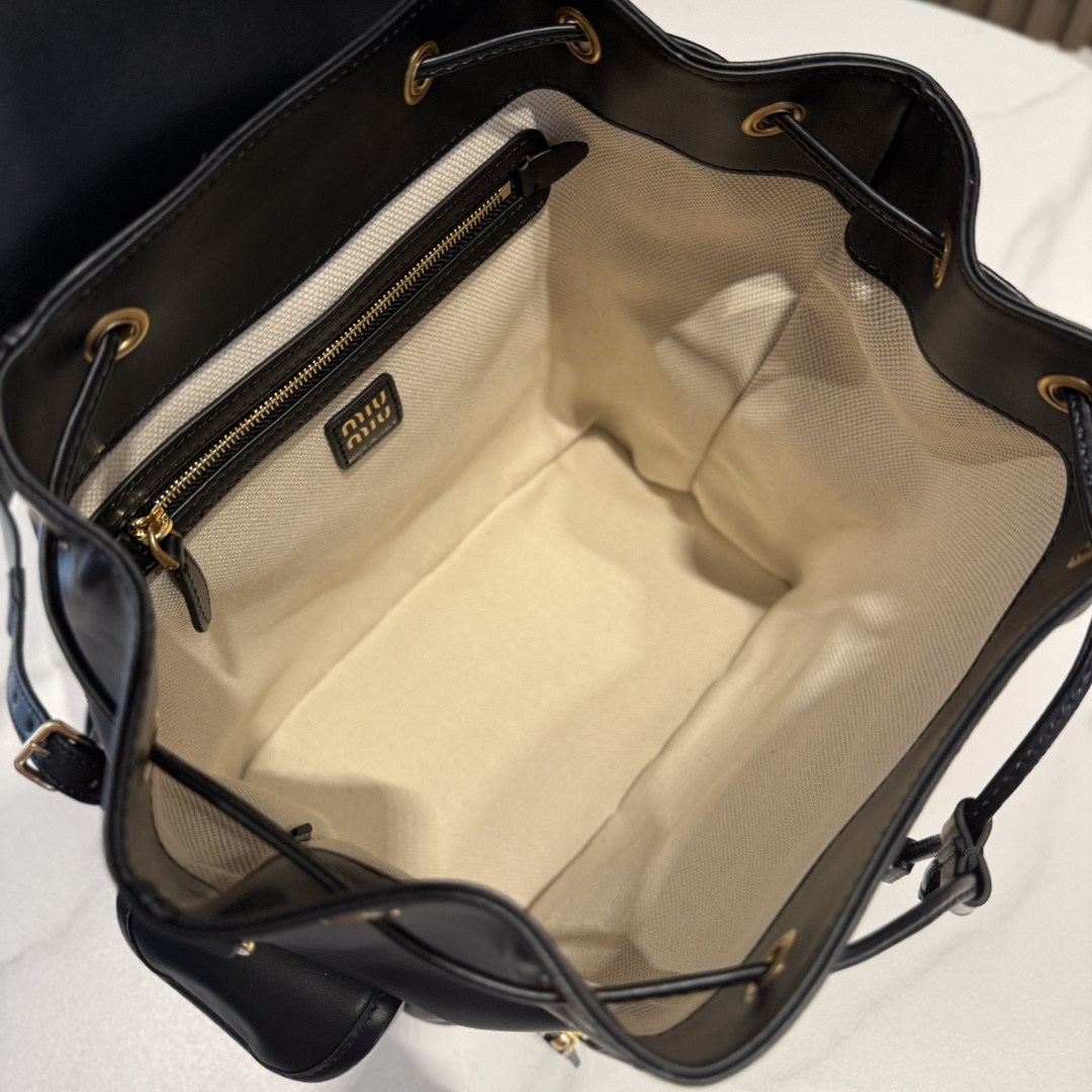 P990 Miu M** 25ss 皮革书包 /在规训与自由之间，背起一座移动城堡  可调节双肩带设计 温柔贴合颈背曲线
方正轮廓型暗藏几何锋芒，顶部抽绳一拉，随时出逃平庸日常

5BZ042
尺寸：25*30*12.5cm