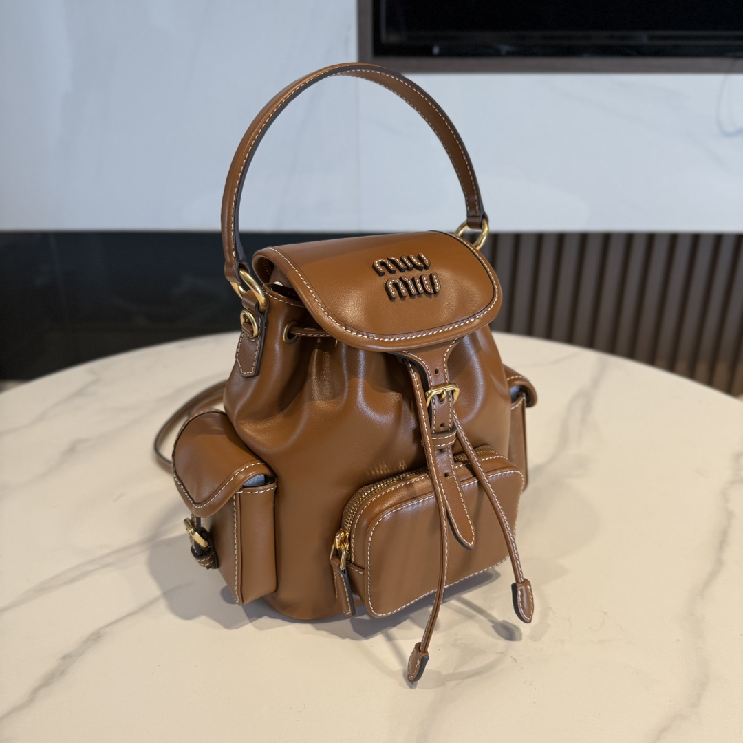 P950 Miu M** 25ss 皮革书包 /在规训与自由之间，背起一座移动城堡  可调节双肩带设计 温柔贴合颈背曲线
方正轮廓型暗藏几何锋芒，顶部抽绳一拉，随时出逃平庸日常

5BZ043
尺寸：18*22*11.5cm