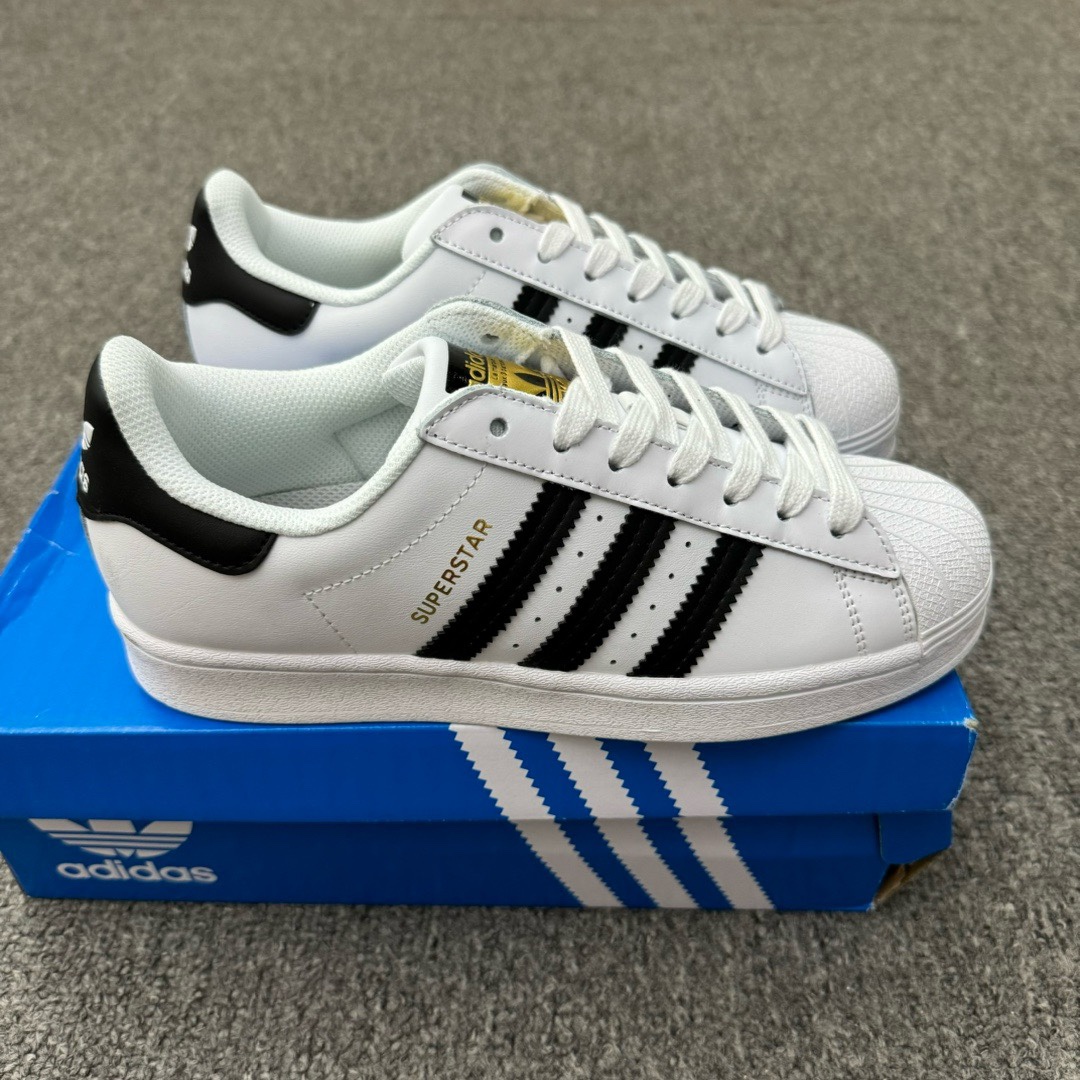 五双十一 (35-45半) 真标带半码 Adidas originals Superstar 阿迪达斯 低帮 白金 贝壳头系列防滑耐磨轻便低邦板鞋男女同款 鞋子采用白色皮革鞋面,搭配鞋身两侧锯齿深金色皮革三条杠Logo及烫印金色Superstary微标框,非常的精致夏天,给人一种清新自然,充满活力的感觉.鞋舌处金色上点缀白色三叶草Logo,后跟金色皮革上点缀白色Adidas三叶草Logo,非常有趣,极具辨识度.橡胶包边大底,经久耐穿. 货号:BA8169 带半码