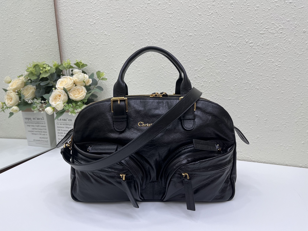 这款 Grand Tour 保龄球包是本季新品，于迪奥二零二五春夏成衣系列发布秀精彩亮相，实用摩登的设计饰以精致的细节。采用黑色褶皱牛皮革精心制作，质地柔软，正面饰以复古金色饰面金属 Christian Dior Paris 标志提升格调。多口袋设计，设有三个拉链隔层，中间隔层的两个大号皮革拉链头点缀以金属 Christian Dior Paris 标志。正面四个拉链口袋可整齐收纳各种小件日常用品。中号款式，搭配带搭扣的顶部皮革手柄和可调节、可拆卸的肩带，可手提或肩背。
尺寸：36 x 22.5 x 12 厘米（长 x 高 x 宽）
编号:M60

号牌:449091