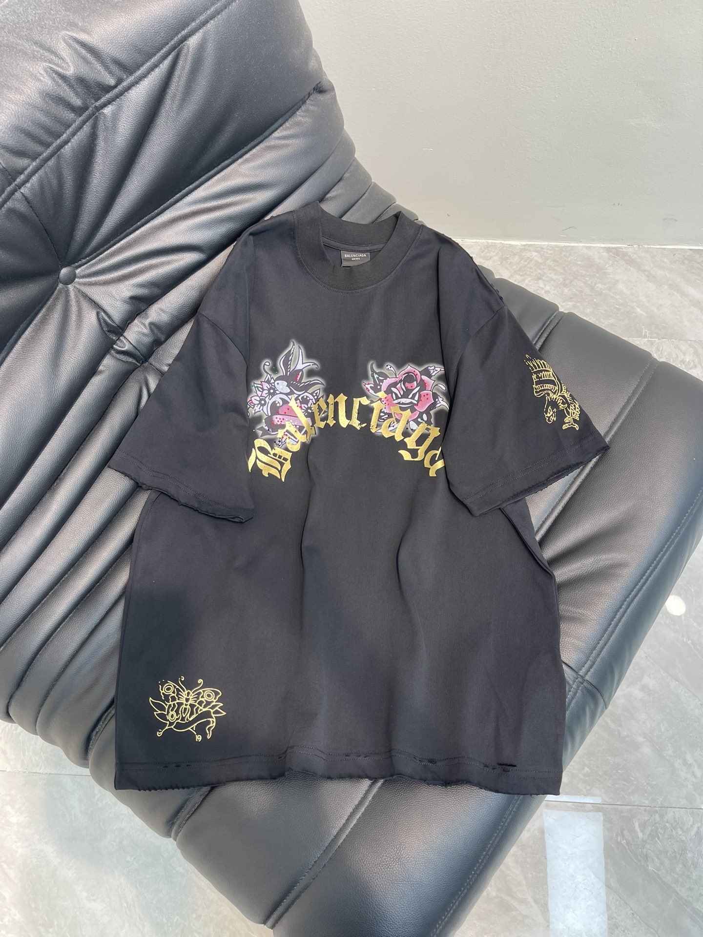 NO:695955,BALENCI*GA/Paris 26's latest model is a Tacky Tattoo artwork embroidered with hot stamping and rhinestones, washed and frayed, distressed short-sleeved T-shirts. Synchronized with the brick cabinet. The fabric is made of Paris ZP custom-woven and dyed 100% cotton with double yarn compact cotton. The weight is 260 grams, and the cloth surface is clean. The cloth pattern is clear, soft and comfortable, and the threads are dyed with no color difference. Printed with environmentally friendly imported materials, the letters are clear and the three-dimensional sense is strong. Restore the brick cabinet.  The ready-made garments are washed and aged, and hand-polished by many people. They are produced with heavy-duty craftsmanship. The version adopts the OS loose shoulder design. The same style for men and women. The color is black. The size is XS-L A, balenciaga, T-shirt, tees, t-shirt,19860909BALENCI*GA/巴黎26最新款 以Tacky Tattoo艺术作品刺绣烫金印花烫钻水洗磨烂做旧短袖T恤.砖柜同步.面料采用巴黎ZP定织定染全棉双纱紧密棉.克重260克,布面干净.布纹清晰,柔软舒适,螺纹釆用定染无色差.采用环保进口材料印花,字母清晰,立体感感强.还原砖柜. 成衣水洗作旧,多位手工磨烂.超重工艺生产.版型釆用OS宽松落肩版型. 男女同款. 颜色黑色 尺码XS-L A,,balenciaga,T-shirt,tees，t-shirt,,Women's clothing