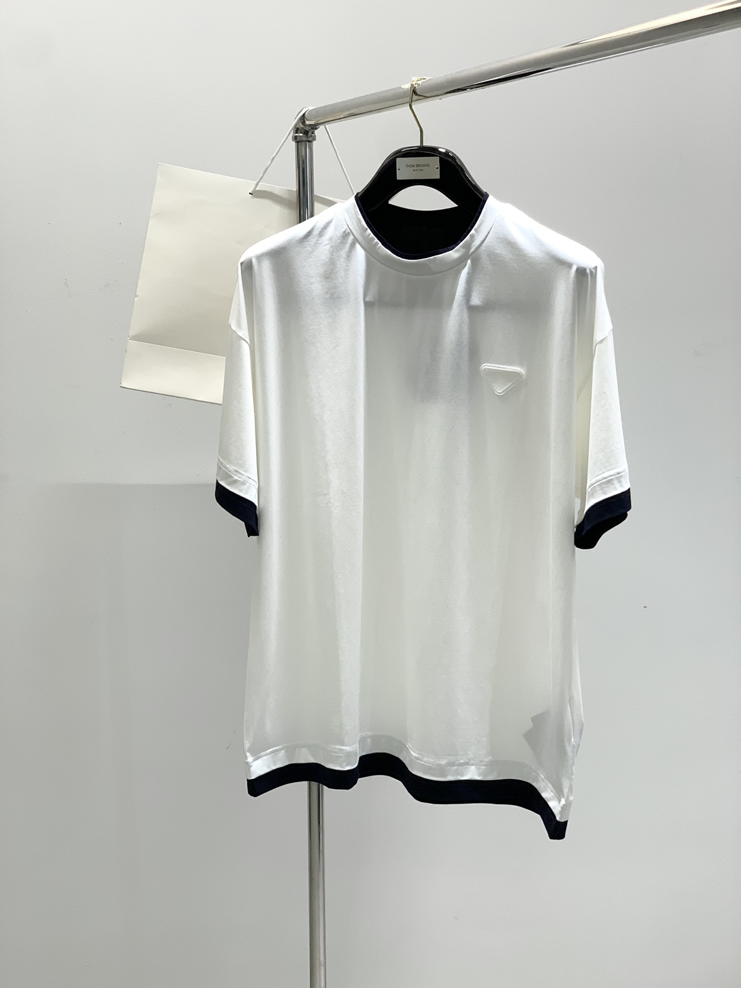 NO:161680,,Prada Men's contrasting color lace-fake two-piece liquid ammonia craft 60 double-sided mercerized combed cotton double-layer round neck loose version short sleeves About style and design Production by P Family, high-quality basic short sleeves, ovsize style, minimalist, detailed, low-key and stylish, the triangle badge with double-layer patch on the left chest restores the signature elements of P Family, low-key but high recognition. The small round neck, solid color, no logo embellishment around the body, the large H-shaped vertical cut silhouette is just right, and the looseness is just right, giving a perfect sense of laziness. It is very outstanding when worn alone or as a mix and layer.  Take low-key and minimalist to the extreme, with the right small details, and the mediocreness without any characteristics. The neckline, cuffs, and hem are decorated with a layer of contrasting colors. The perfect scale reveals the white or dark blue edges. The visual layering effect of two-piece stacking is visually shaped, and the workmanship is unquestionable. About fabrics and craftsmanship 95 cotton 5 spandex, 60S environmentally friendly planted long woven cotton, combed with high-volume high-density combed and double-sided merceration technology, with a fineness of 1/2-1/3 of ordinary cotton, delicate fabric surface, comfortable body feel, German OEKO-TEX100 certification, healthy and environmentally friendly, liquid ammonia process treatment, has certain wrinkle resistance and is easy to handle. Size S-XL Size Shoulder Sleeve Long Sleeve Long S116 59 71 20  M120 60 73 20.5 L124 6175 21 XL128 627722,,prada,T-shirt,alexander wang19860909,普拉达 男款撞色镶边假两件液氨工艺60支双面丝光精梳棉双层圆领宽松版短袖 关于款式及设计 P家出品,高品控的基础短袖,ovsize版型,极简,细节到位,低调且有品,左胸前双层贴布的三角徽章,还原了P家的招牌元素,低调但高识别度. 小圆领,纯色系,周身无一logo点缀,大身H型的立裁廓形,松量拿捏正好,给予恰到好处的慵懒感,单穿或作为混搭叠穿相当出彩. 把低调和极简拿捏到极致,小细节恰到好处的加持,又不至于毫无特色的平庸化.领口,袖口,下摆,以双层叠合的方式衬了一层撞色边作为点缀,尺度正好的露出白边或深蓝边,在视觉上有假两件叠搭的层次效果,做工版型都无需置疑的正点. 关于面料及工艺 95棉5氨纶,采用60S的环保种植长绒棉,以高支数高密度精梳织造,双面丝光工艺加持,细度为普通棉的1/2-1/3,布面细腻,体感舒爽,德国OEKO-TEX100认证,健康环保,液氨工艺处理,具有一定的抗皱性能,易于打理. 尺码S-XL 码数胸围肩宽衣长袖长 S116 59 71 20 M120 60 73 20.5 L124 6175 21 XL128 627722,,prada,T-shirt,alexander wang,Men's clothing