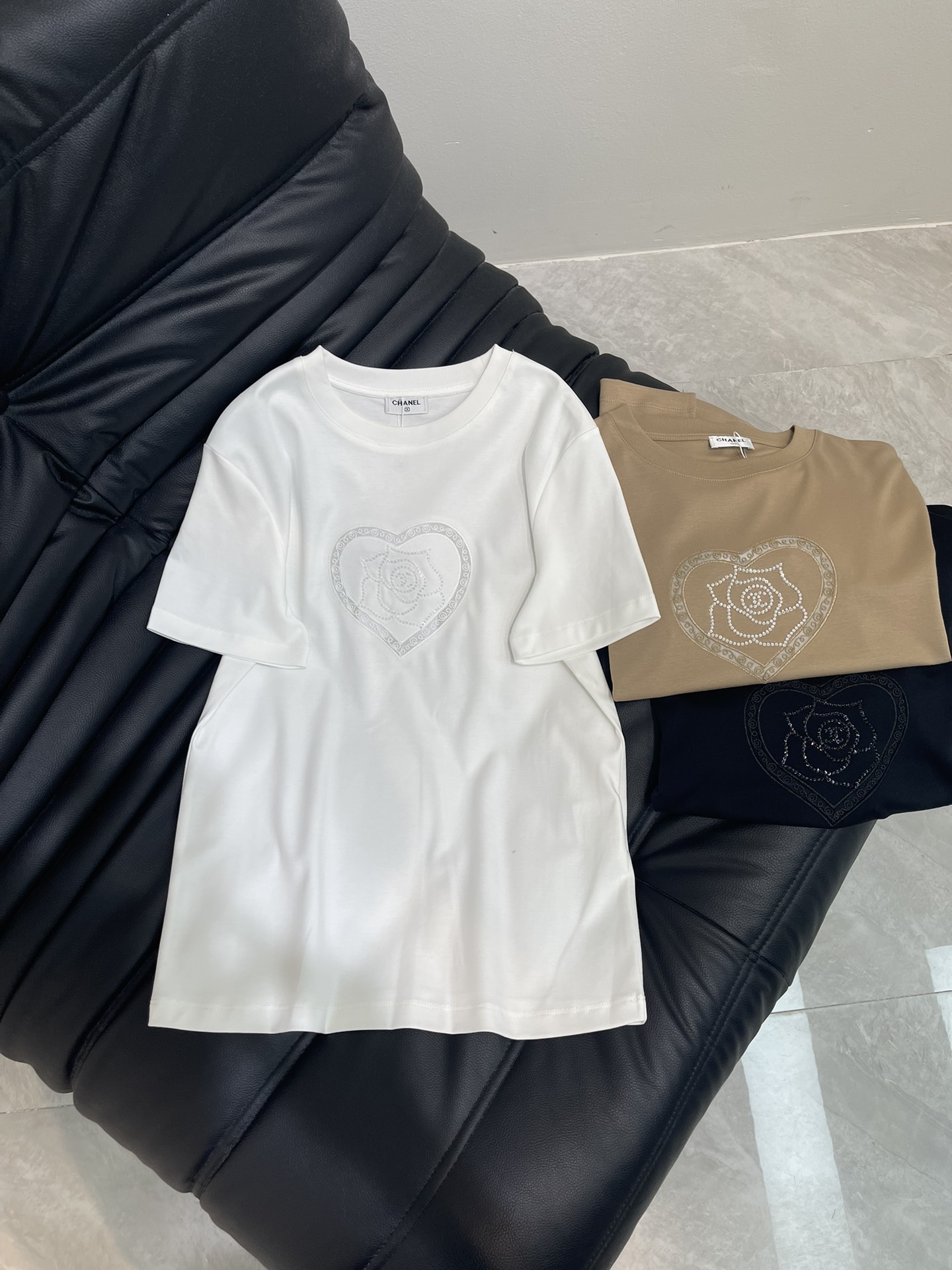 NO:334125,Chane* embroidered beaded camellia custom YB mercerated cotton material breathable and comfortable, full texture. Regular short-sleeved T-shirt cut to highlight the brand style. Made of gram-weight pure cotton, slightly elastic, and slimming visual effect. The three-dimensional rhinestone beads on the chest outline the camellia with the iconic logo. The outer layer is exquisite and fashionable around the love pattern. The temperament is versatile. The inner wear is customized. Customized surface accessories. Accurate version. High-version 3 colors. SML, chanel, T-shirt,tees, t-shirt,alexander wang.19860909Chane*刺绣订珠山茶花 定制YB丝光全棉材质 透气舒适 质感十足 常规短袖T恤裁剪 凸显品牌格调 采用克重纯棉制成 略带有弹力 呈现显瘦视觉效果 胸前立体水钻钉珠勾勒出带有标志性徽标山茶花造型 外层围绕爱心图案精致时髦 气质百搭 单穿内搭都 定制面辅料 认准版本 高版本 3色 SML,,chanel,T-shirt,tees，t-shirt,alexander wang,Women's clothing