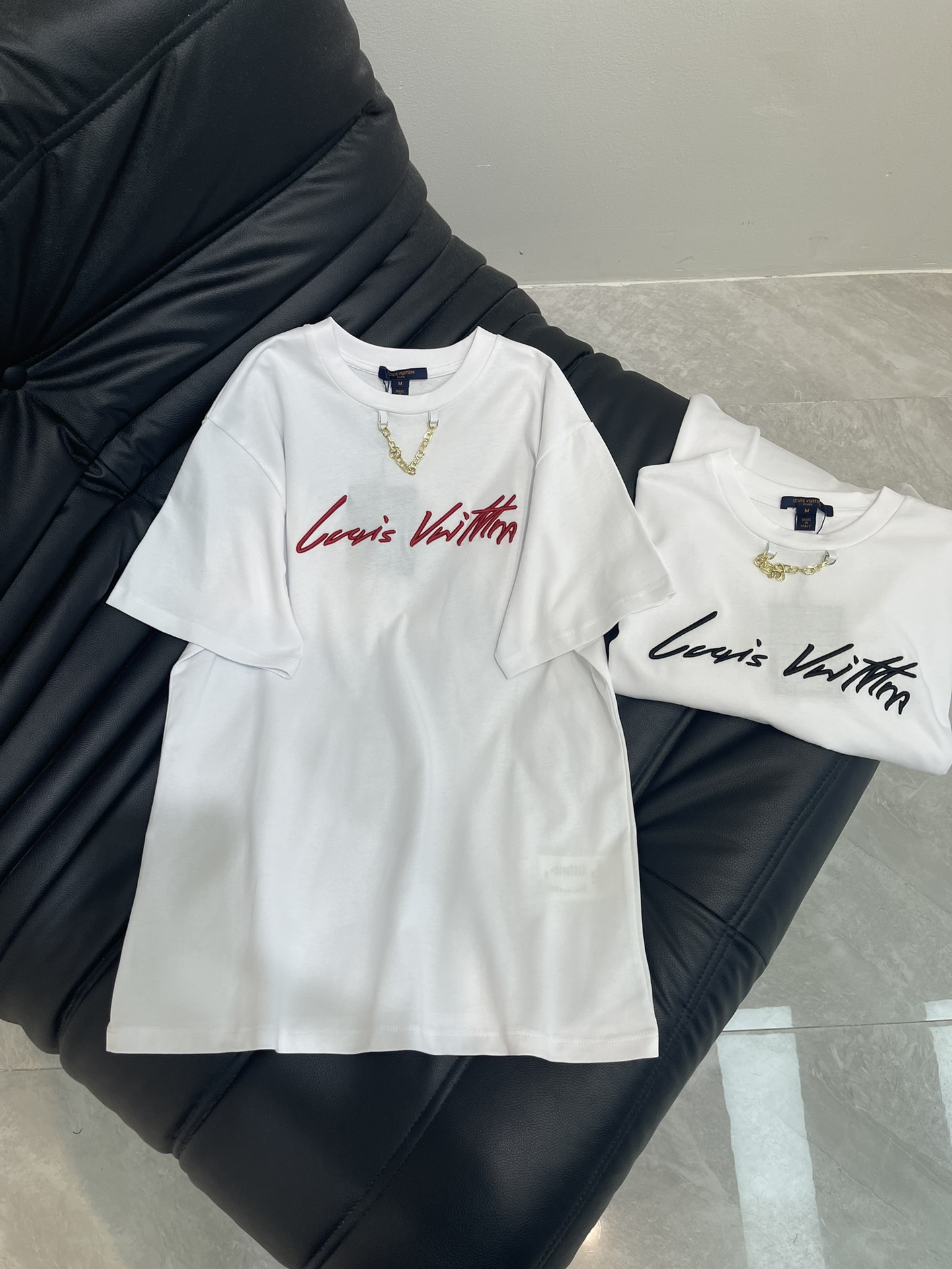 NO:411823,Louis Vuitto*25 spring and summer new round neck embroidered letter chain short-sleeved T-shirt custom YB native cotton material breathable and comfortable, full texture, oversized loose T-shirt cut, highlighting the brand style, made of gram-weight pure cotton, slightly elastic, giving a slim visual effect, the neckline is designed with metal letter chains, embroidered letter logo decoration on the chest, the floral style is casual and free, showing high-end style, and the inner wear is brilliant and fashionable. SML,,louis vuitton,versace,T-shirt,tees,t-shirt,alexander wang19860909Louis Vuitto*25春夏新款圆领刺绣字母链条短袖T恤 定制YB原生全棉材质 透气舒适 质感十足 廓形oversized宽松T恤裁剪 凸显品牌格调 采用克重纯棉制成 略带有弹力 呈现显瘦视觉效果 领口以金属字母链条作设计亮点 胸前刺绣字母徽标装饰 花体风格随性自由 彰显高级格调 单穿内搭都出彩时髦 SML,,louis vuitton,versace,T-shirt,tees，t-shirt,alexander wang,Women's clothing