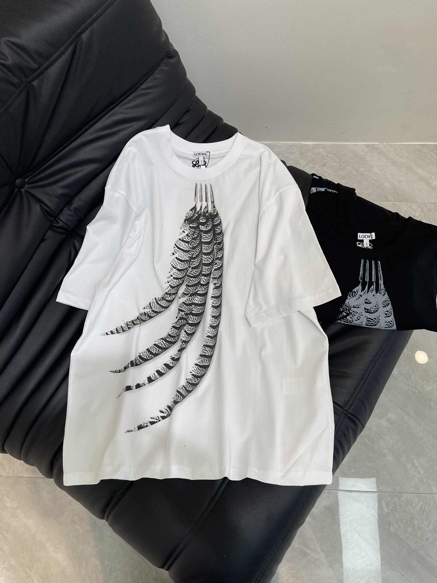 NO:421132,Loew*25 spring and summer new feather printed short-sleeved T-shirt custom YB native cotton material breathable and comfortable, full texture Loose Oversized T-shirt cut highlights the brand style Made of gram-weight pure cotton, full of drape and presents a slimming visual effect YB development The whole garment chest uses printing technology and contrasting colors to outline the feather pattern. The logo embroidery behind the back Elegant artistic sense to enhance the brand identity. Fashion and high-end feel immediately. Create a personal style. Fashionable and relaxed. The inner wear is brilliant and fashionable. SML,,loewe,versace,T-shirt,tees,t-shirt,alexander wang19860909Loew*25春夏新款羽毛印花短袖T恤 定制YB原生全棉材质 透气舒适 质感十足 宽松OversizedT恤裁剪 凸显品牌格调 采用克重纯棉制成 垂坠感十足 呈现显瘦视觉效果 YB开发 整件成衣胸前利用印花工艺和撞色勾勒出羽毛图案 背后徽标刺绣 优雅艺术感加强品牌标识度 时尚高级感立现 打造个性风格 时髦松弛 单穿内搭都出彩时髦 SML,,loewe,versace,T-shirt,tees，t-shirt,alexander wang,Women's clothing