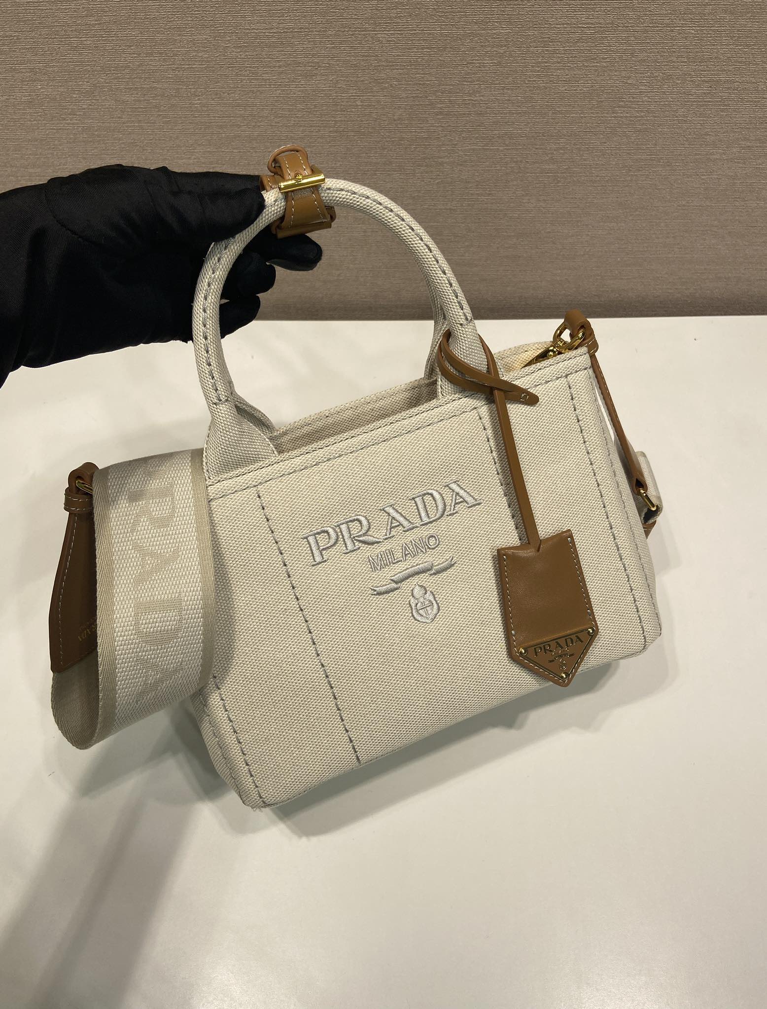 
💰580🎉新品手袋🎉1BA038中性色🎉🎉
这款迷你手袋受航海风尚隽永元素启发，重新诠释典范型格。选用棉质帆布制成，皮革饰边展示精致百变个性。帆布手提柄，可拆卸可调节徽标印花编织饰带肩带，可拆卸皮革钥匙扣，手提/肩背都可以，容量空间大，太美了，又是一款永久不过时爆款🎉🎉值得拥有🎉🎉
长22x高15x底13cm🎉🎉🎉💰💰💰
