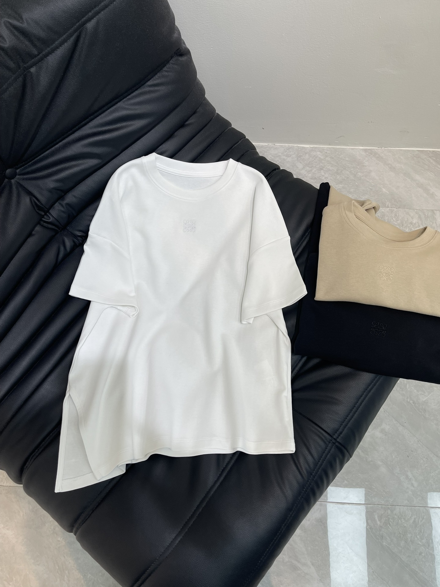 NO:431282,Loew*25 spring and summer new embroidered totem slit short-sleeved T-shirt Customized YB thickened cotton material breathable and comfortable, full texture Full of texture Loose short-sleeved T-shirt cut to highlight the brand style Made of gram-weight pure cotton, full of drape, presenting a slimming visual effect The chest is embroidered with embroidery technology to outline the totem logo to enhance brand identity. Combined with shoulder drop, cover the arms and shoulders, modify the lines, fashionable and high-end feeling, hem side slits to create a personalized style, fashionable and relaxed, single wear inner wear is brilliant and fashionable SML,,loewe,T-shirt,tees,t-shirt,alexander wang19860909Loew*25春夏新款刺绣图腾开衩短袖T恤 定制YB加厚全棉材质 透气舒适 质感十足 落肩宽松短袖T恤裁剪 凸显品牌格调 采用克重纯棉制成 垂坠感十足 呈现显瘦视觉效果 胸前利用刺绣工艺勾勒出图腾徽标 加强品牌标识度 配合落肩遮挡手臂肩膀 修饰线条 时尚高级感立现 下摆侧面开衩 打造个性风格 时髦松弛 单穿内搭都出彩时髦 SML,,loewe,T-shirt,tees，t-shirt,alexander wang,Women's clothing