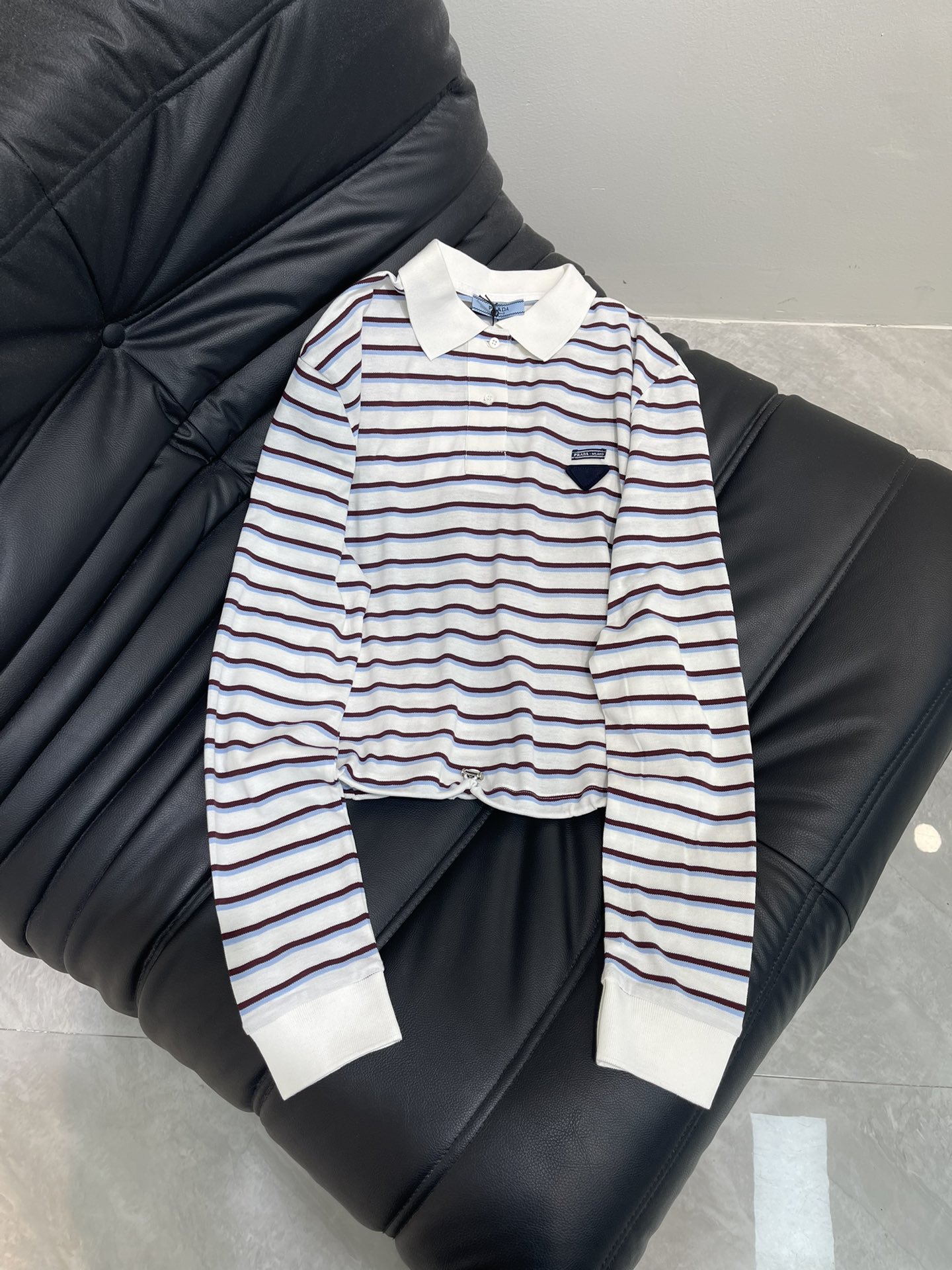 NO:434391,Prad*2025 new product is available. Lapel striped long-sleeved top. Customized YB red cotton. It has holes. Breathable and comfortable. Oversized silhouette long-sleeved cut. The buttons are half-open for easy adjustment. Highlight the brand style. Made of gram-weight pure cotton. It is slightly elastic. It presents a slim visual effect. The whole body stripes are intertwined. The style is refreshing and full of navy. The three-dimensional triangle letter logo on the chest. The style is relaxed and fashionable. The style is instantly taken to a step. The wide-fitting hem is adjusted by drawstring to create a personalized style of high street. SML,,prada,versace,alexander wang19860909Prad*2025新品上架 翻领条纹长袖上衣 定制YB朱地全棉材质 自带孔洞 透气舒适 Oversized廓形长袖裁剪 纽扣半开襟便于调节 凸显品牌格调 采用克重纯棉制成 略带有弹力 呈现显瘦视觉效果 通体条纹交织 风格清爽充满海军气息 胸前立体三角字母徽标造型 松弛时髦 瞬间格调走上一个台阶 宽大版型衣摆以抽绳调节松紧 打造高街个性风格 SML,,prada,versace,alexander wang,Women's clothing